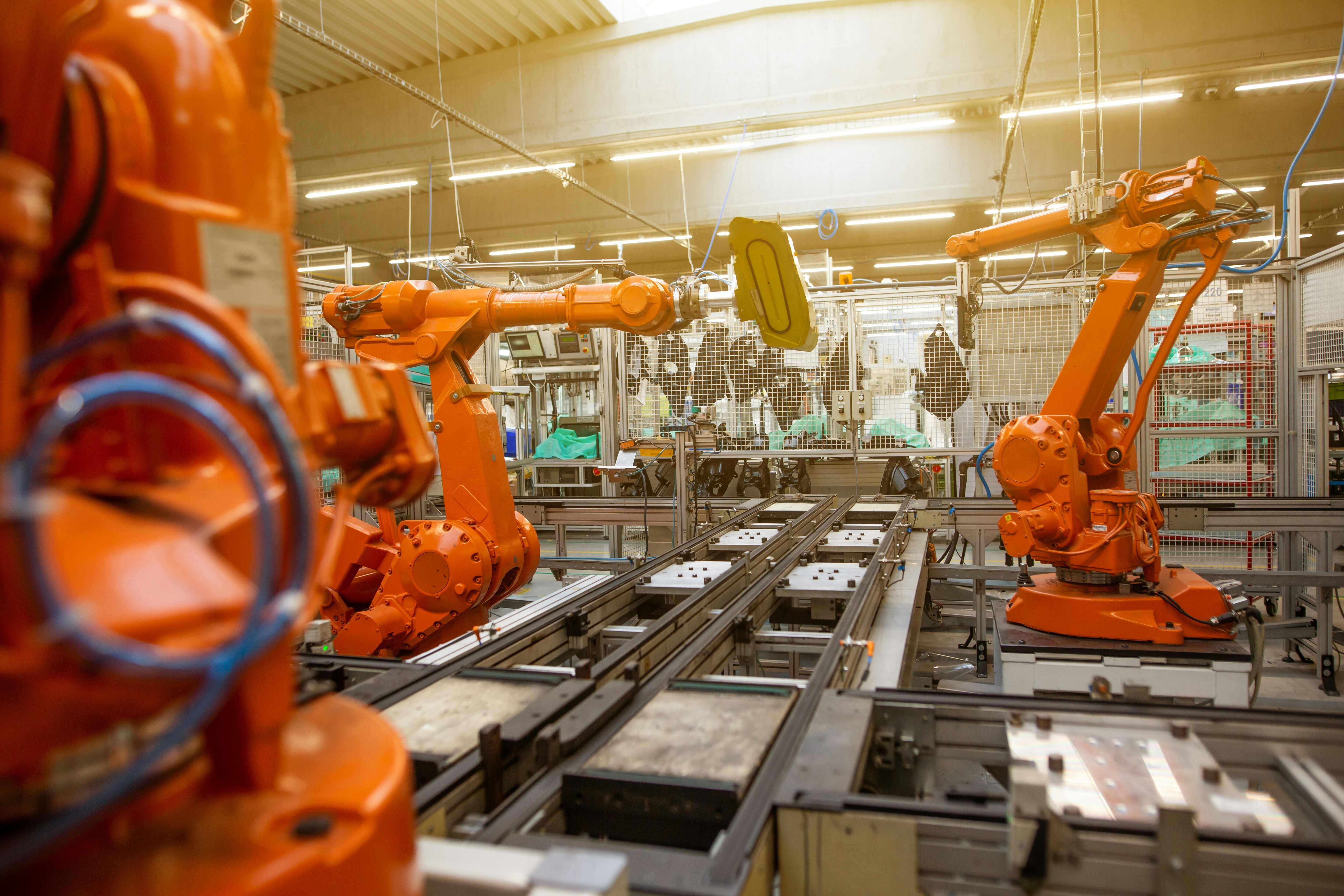 Orange robotic arms in manufacturing line: Resilience in manufacturing now depends on adaptability