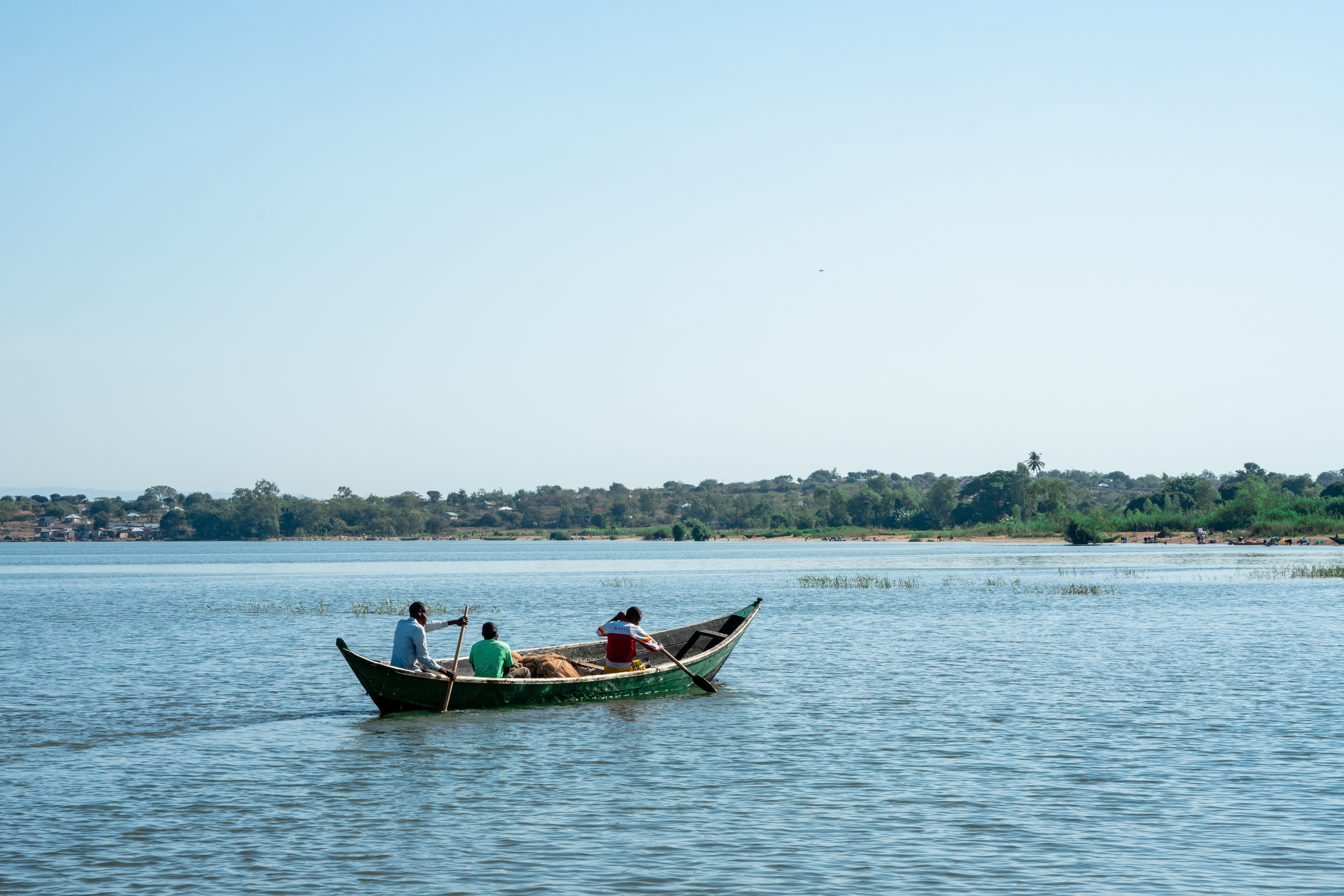 Three fisherman are seen on a boat.