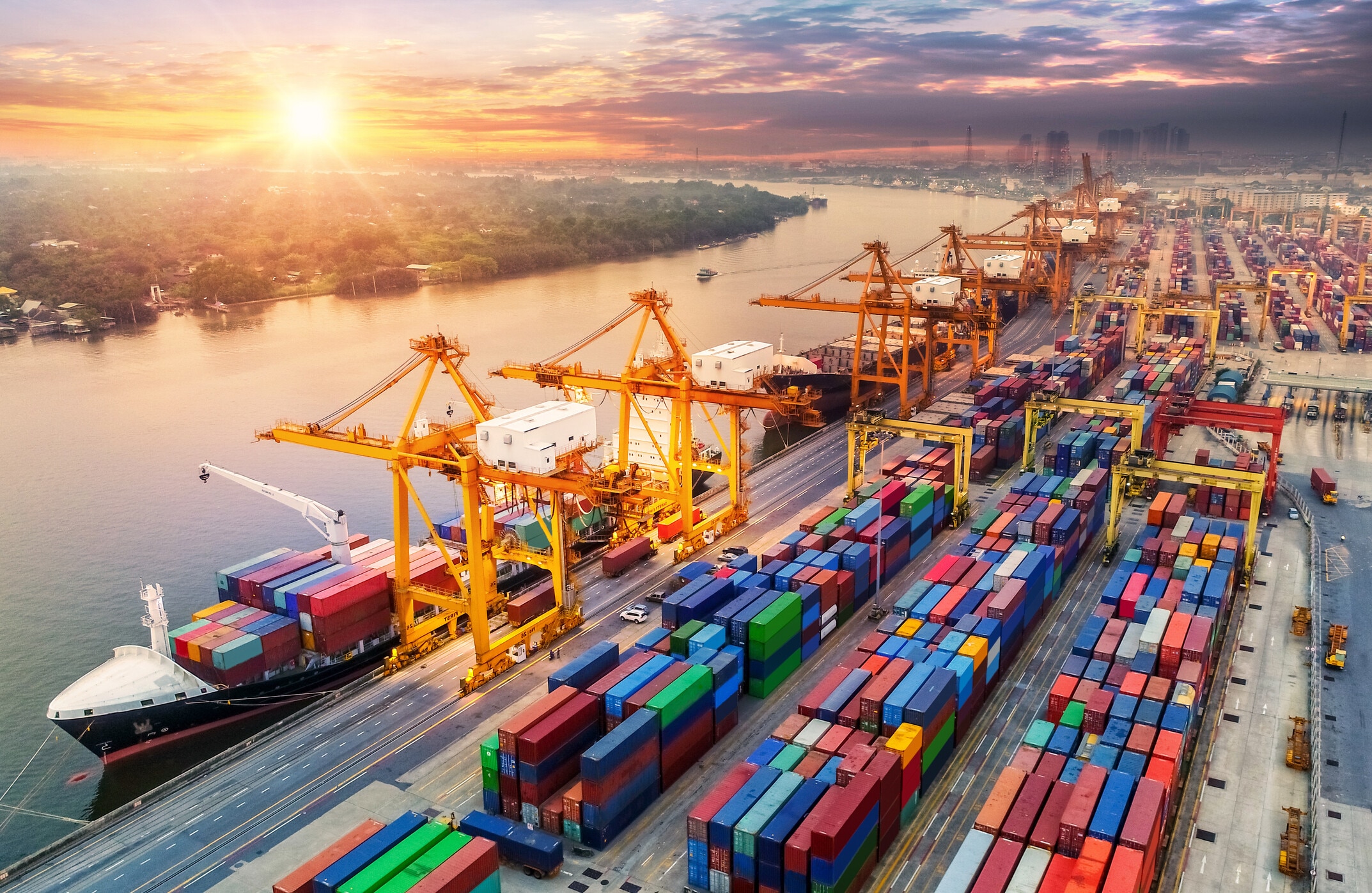 Logistics and transportation of Container Cargo ship and Cargo plane with working crane bridge in shipyard at sunrise, logistic import export and transport industry background; industrial transformation.