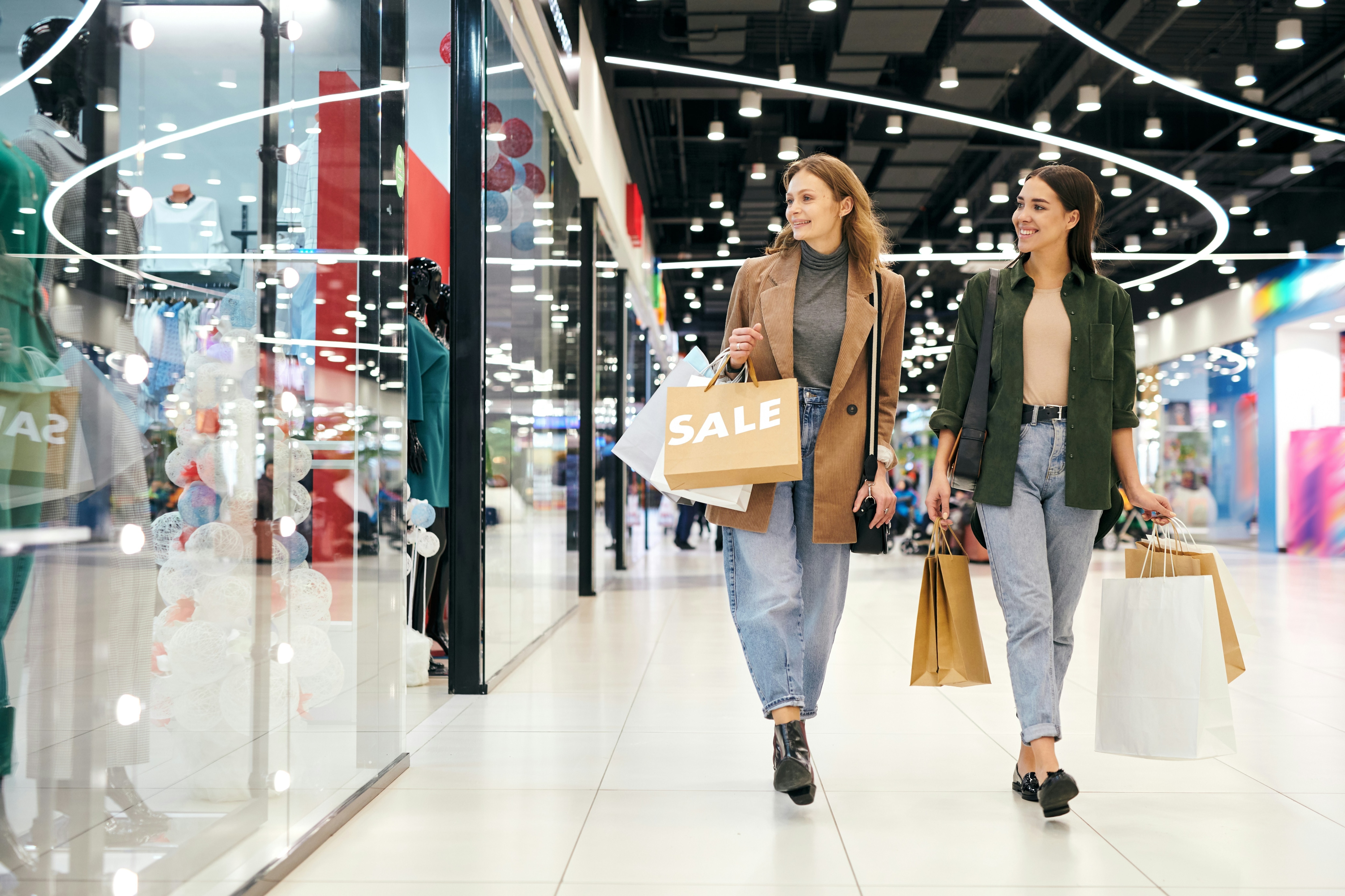 Two women look into a shop window carrying sale bags: Future-proofing retail requires building the underlying intelligence of the business