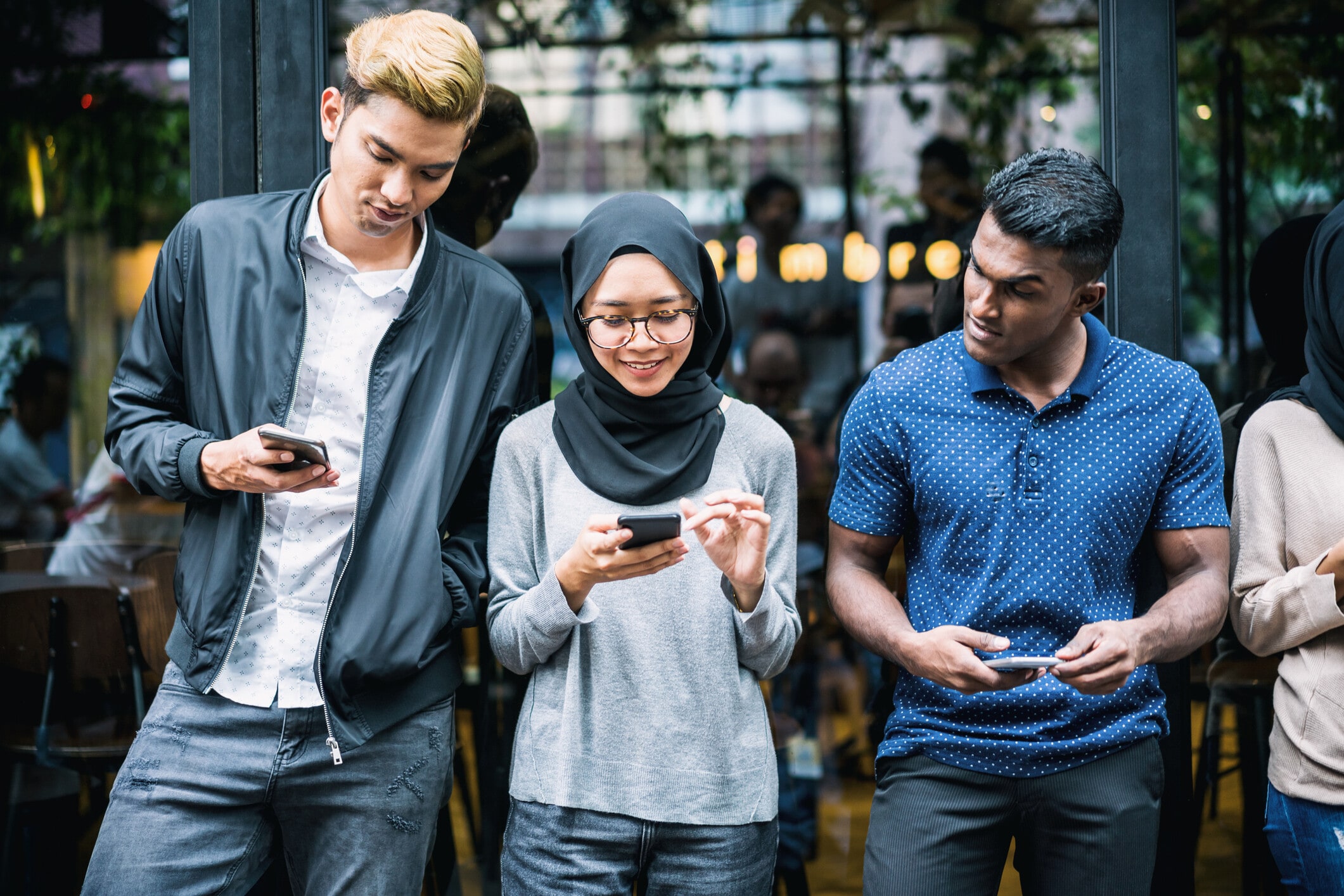 Small group of young adult using smartphones for communication. Cybersecurity and Gen Z
