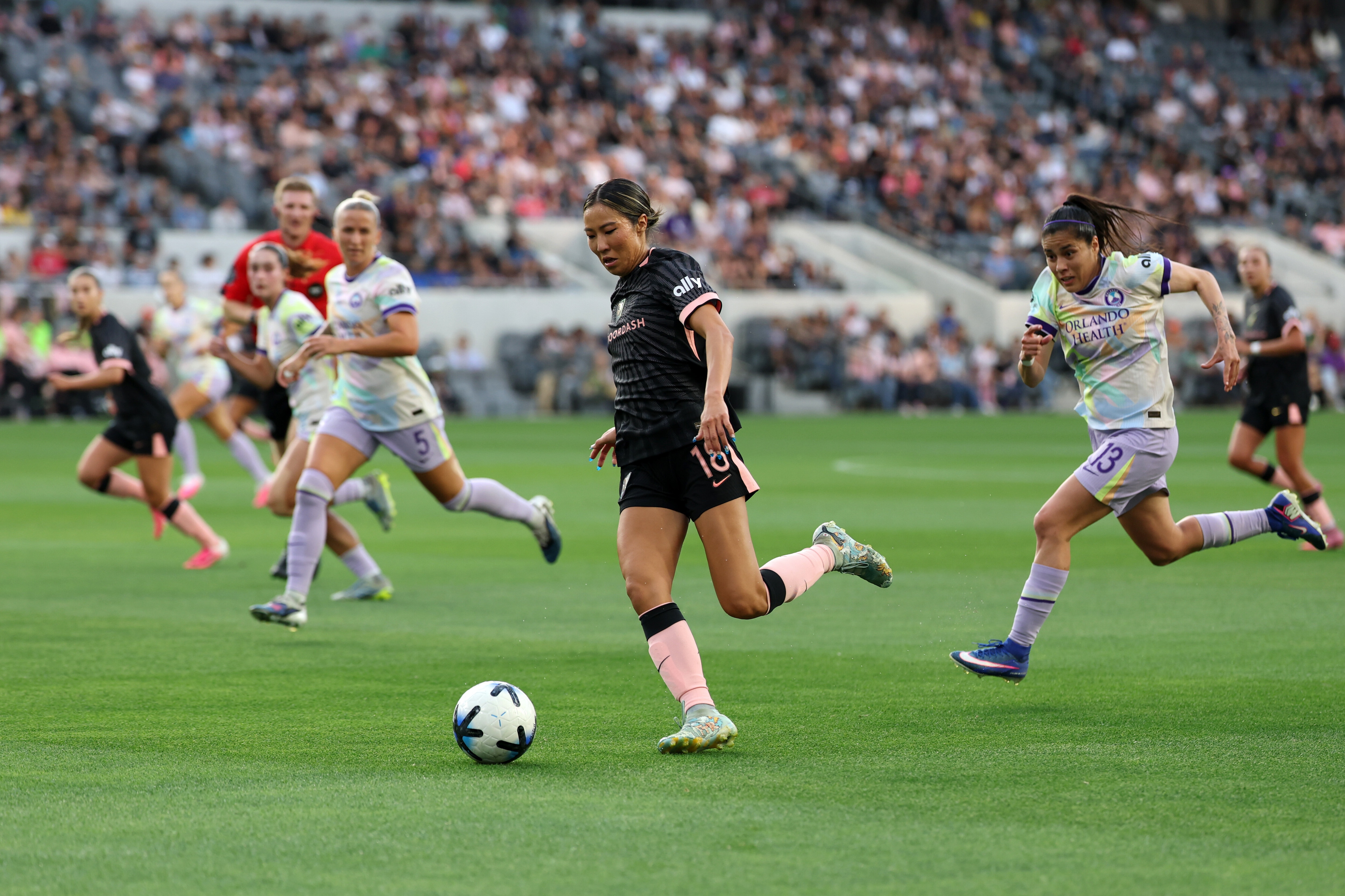 Angel City FC forward Jun Endo dribbles the ball ahead of Orlando Pride forward Jacqueline Ovalle as women's sports gain in popularity. 