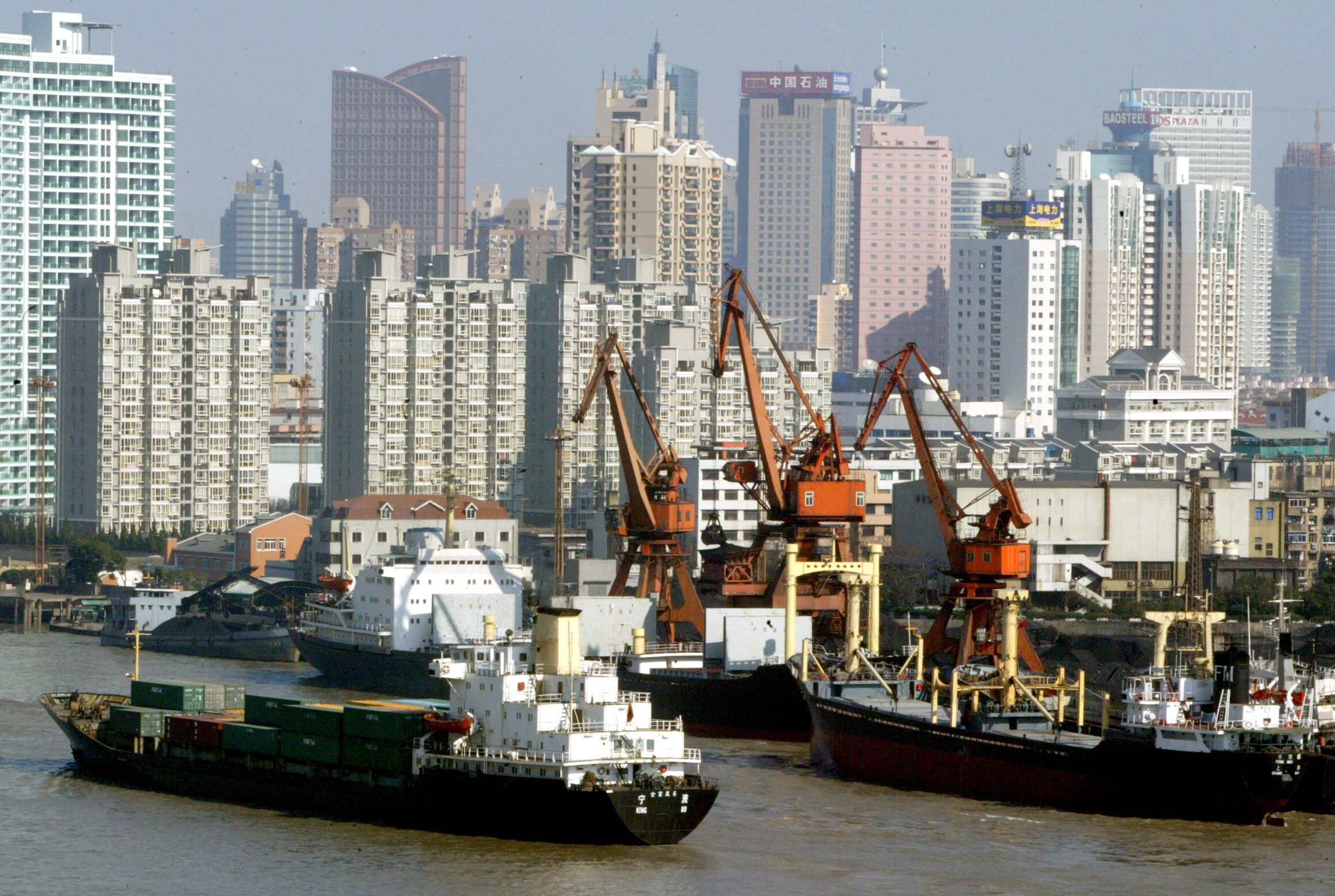 A container ship cruises past a shipyard along the iconic Huangpu River in Shanghai, China's business capital and the world's third busiest container port January 14, 2004. China has become the world's factory and Shanghai has enticed billions of dollars in foreign investment, much of it from Hong Kong shipping firms. Picture taken January 14, 2004: Coherent governance is critical to achieve ambitious decarbonization targets