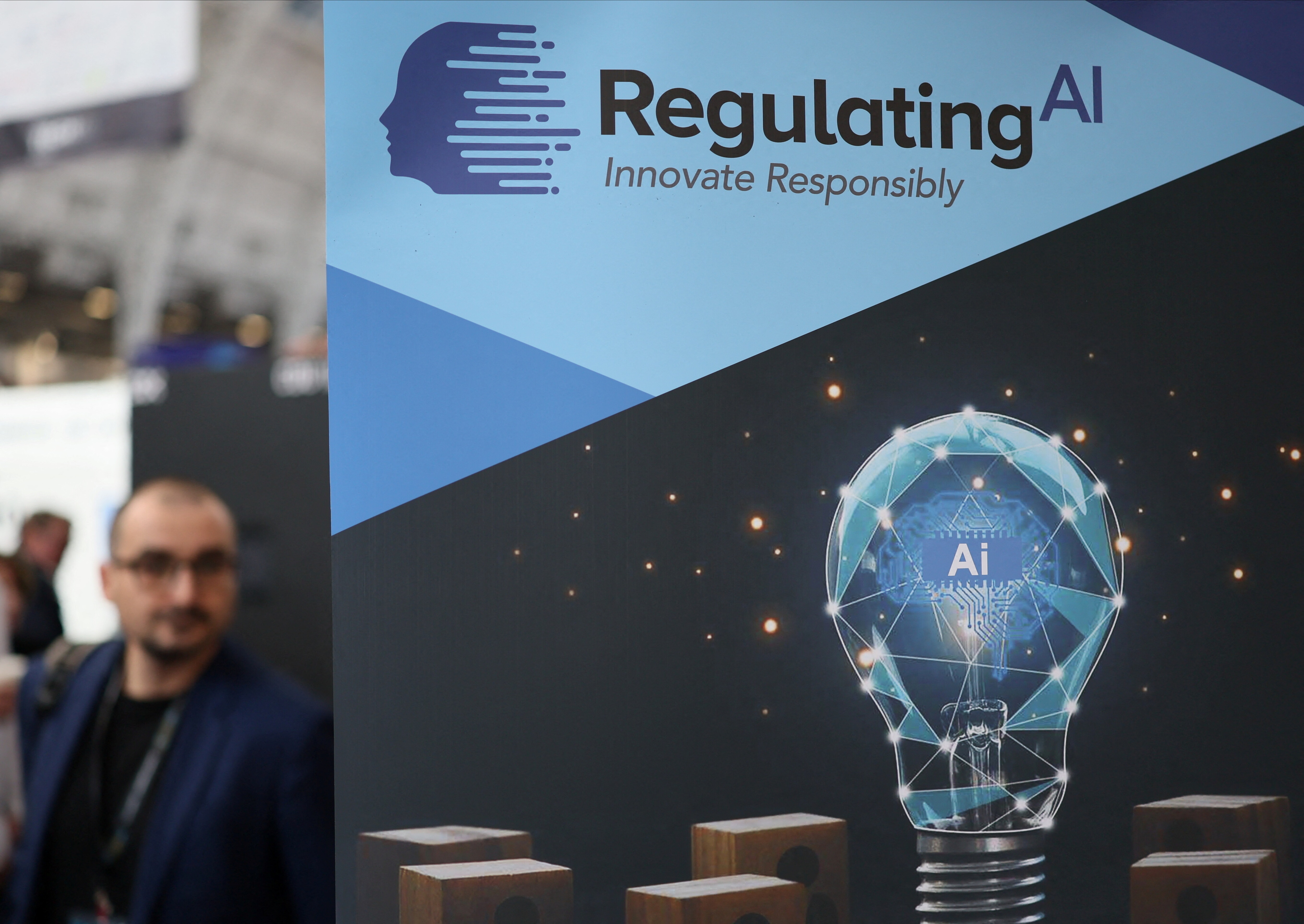 A banner shows message reading "Regulating AI", during the AI & Big Data Expo 2025 at the Olympia, in London, Britain, February 5, 2025: AI governance must adapt continuously, not periodically