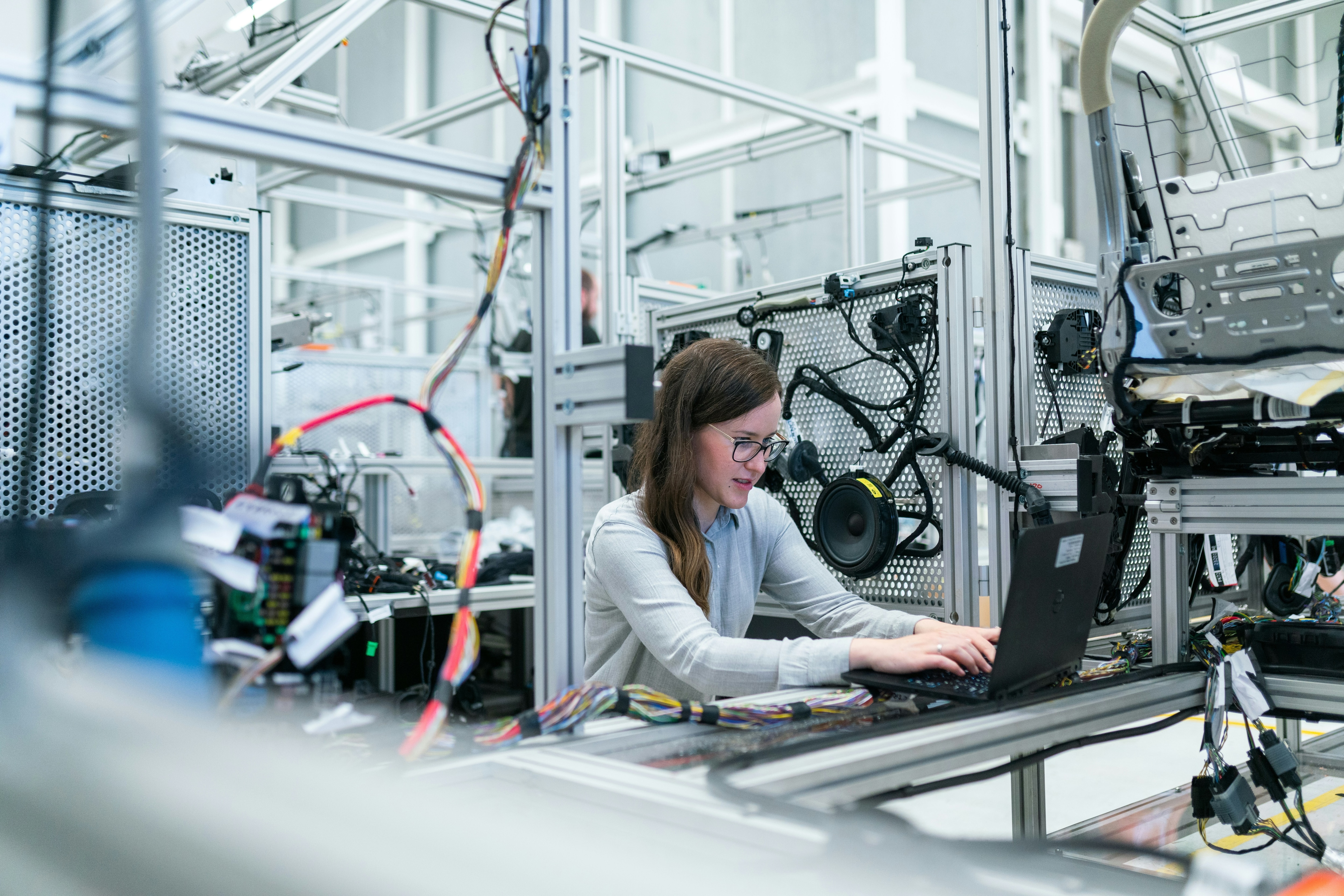 A woman at a laptop with hardware around her: Workforce preparedness means connecting learning to real workplaces