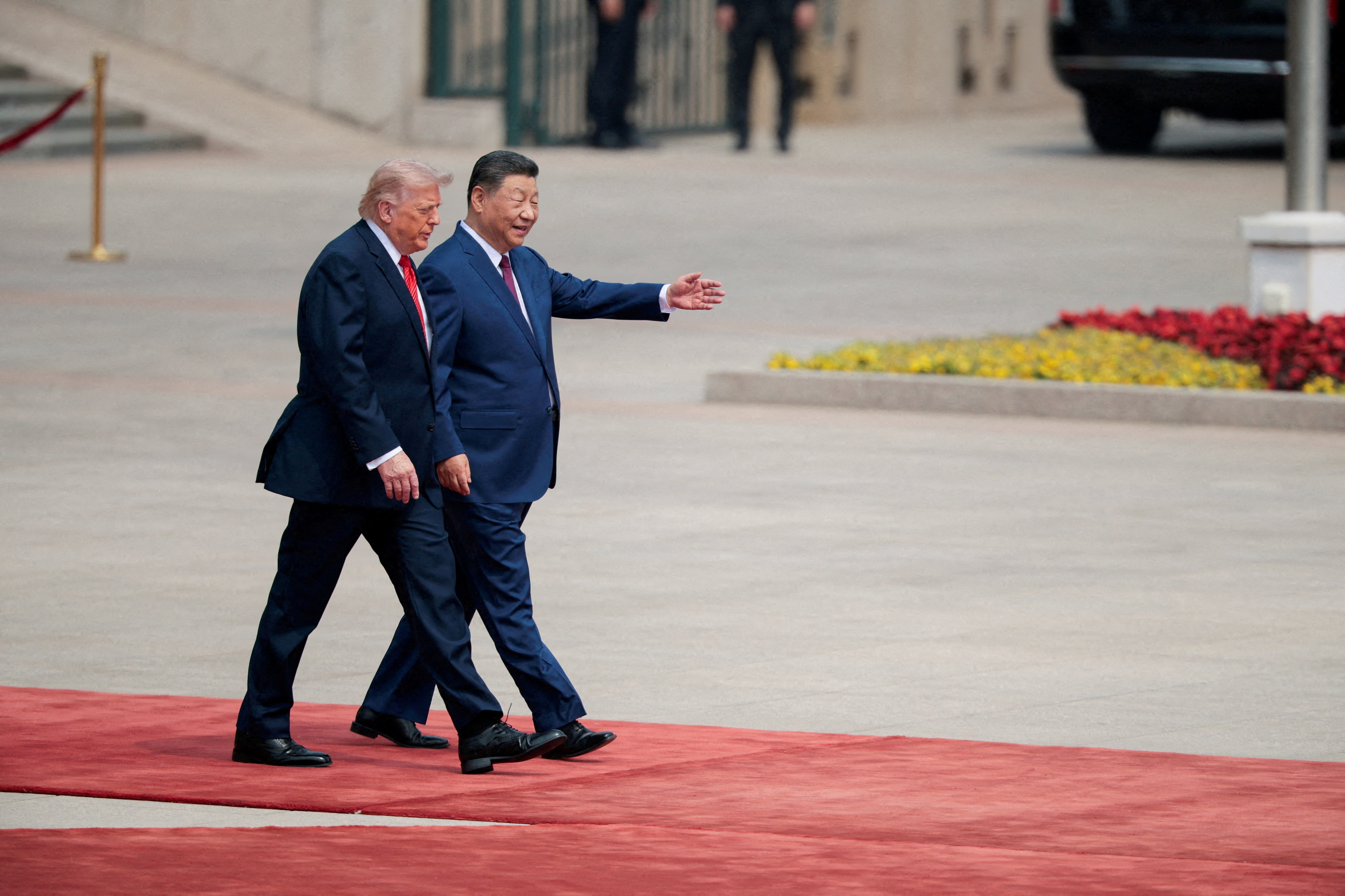US President Donald Trump walks with Chinese President Xi Jinping upon arrival at the Great Hall of the People in Beijing, China, May 14, 2026.