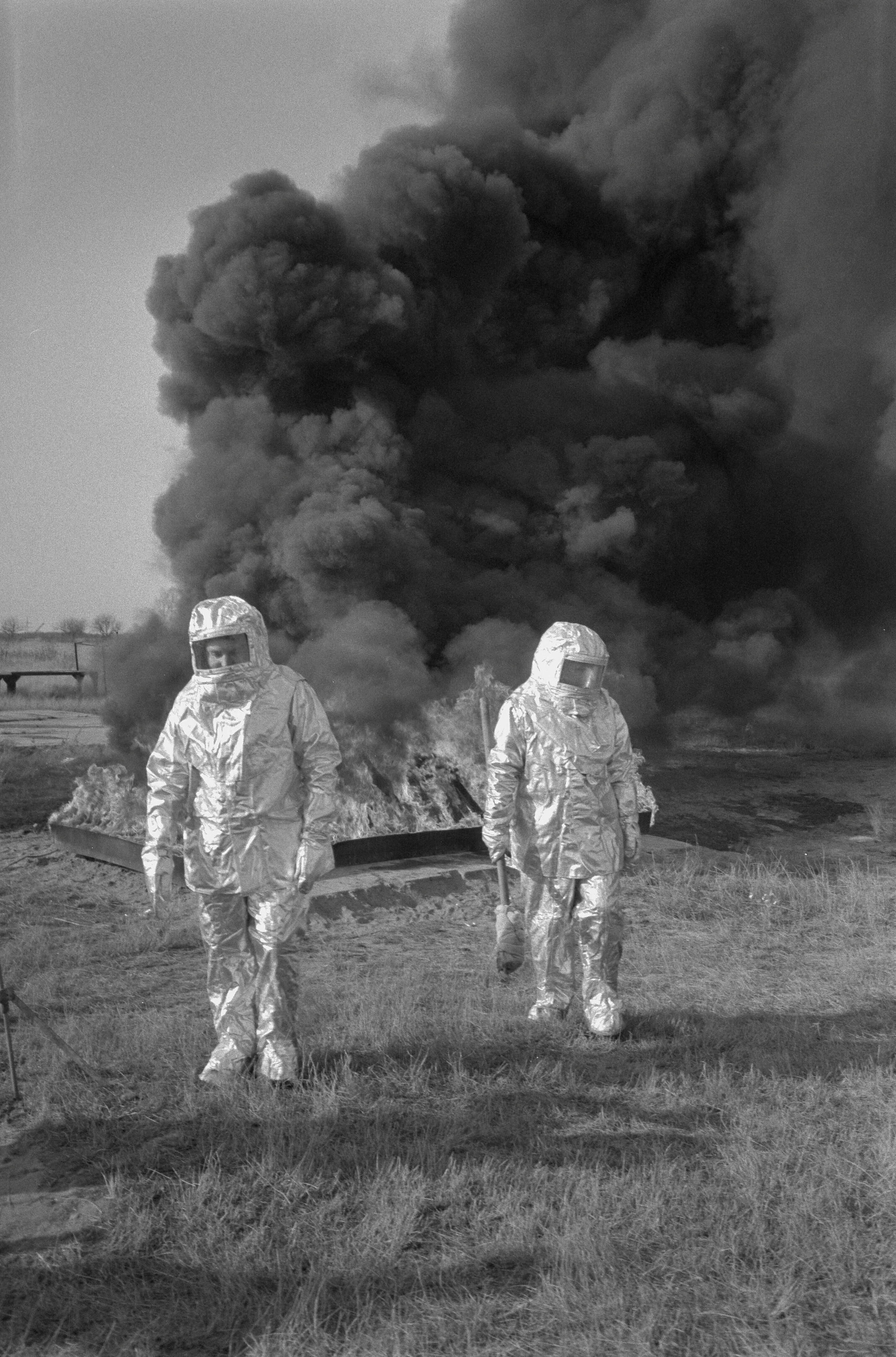 Two Soviet firefighters wearing asbestos suits walk away from a burning pile of hashish worth $20 million after setting it ablaze during a drug destruction operation in Soviet Union, October 13, 1987. REUTERS/Dominique Dudouble 87334093