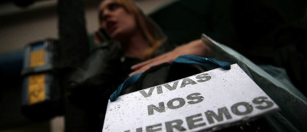 A woman talks on her cell phone as she carries a sign that reads "We want us alive" during a demonstration to demand policies to prevent gender-related violence, Argentina, October 19, 2016. REUTERS/Marcos Brindicci - RTX2PLCI