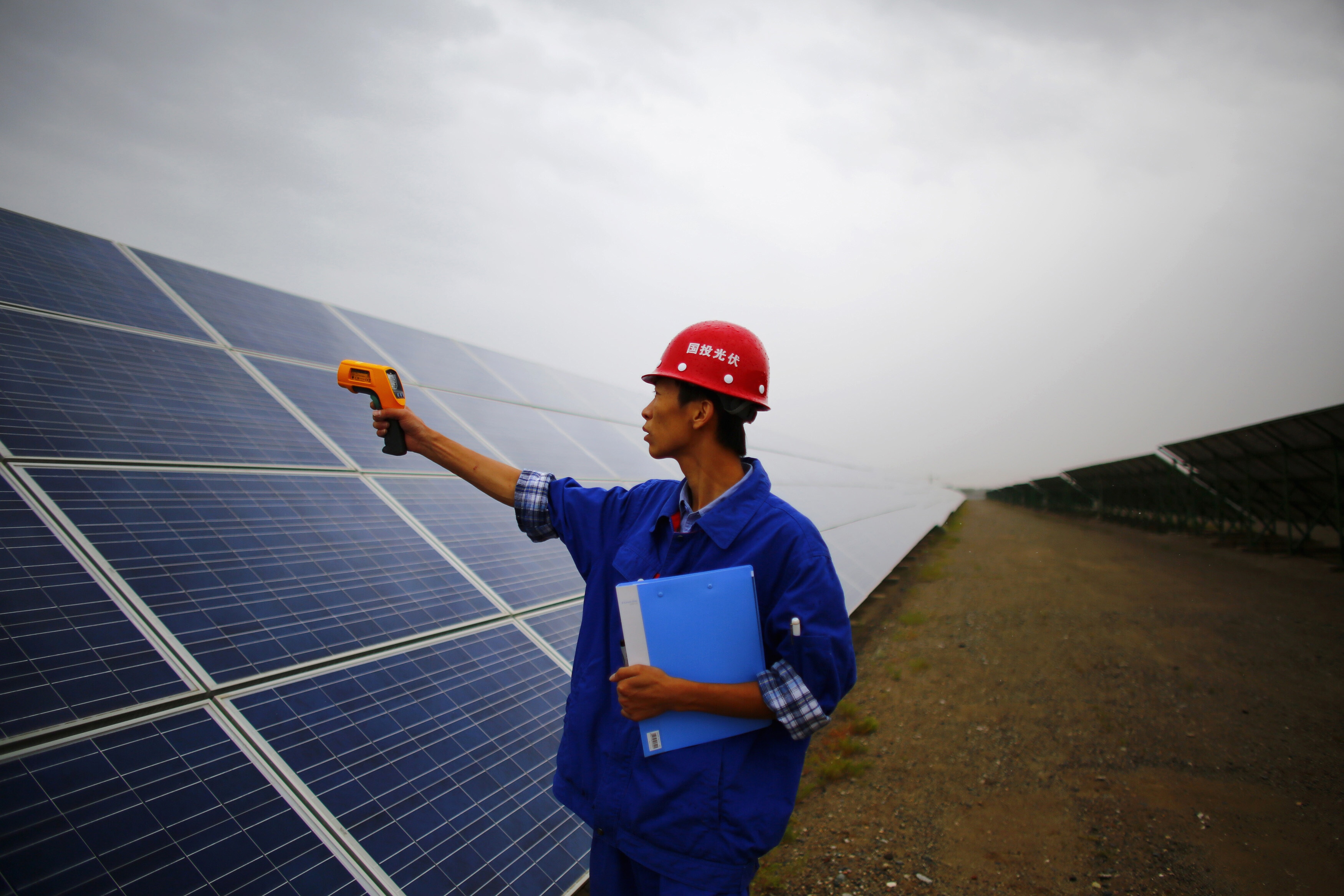 A worker inspects solar panels at a solar farm in Dunhuang, 950km (590 miles) northwest of Lanzhou, Gansu Province September 16, 2013.  China is pumping investment into wind power, which is more cost-competitive than solar energy and partly able to compete with coal and gas. China is the world's biggest producer of CO2 emissions, but is also the world's leading generator of renewable electricity. Environmental issues will be under the spotlight during a working group of the Intergovernmental Panel on Climate Change, which will meet in Stockholm from September 23-26. Picture taken September 16, 2013: Boom loops are a positive self-reinforcing cycle that can be triggered by investment in clean tech
