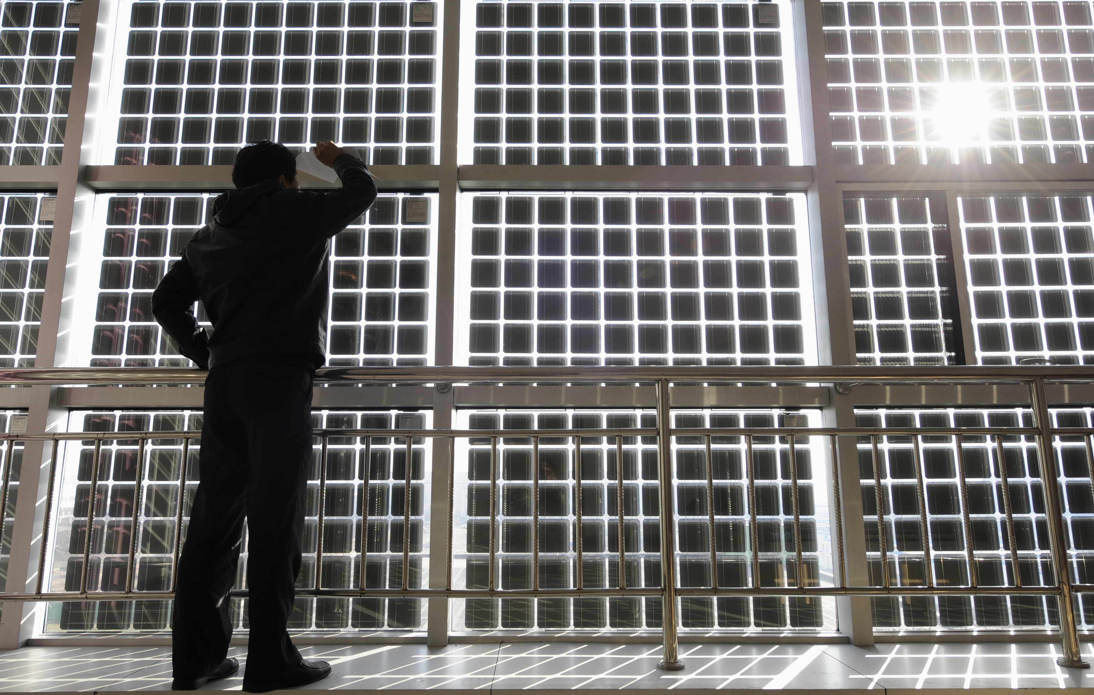 A visitor looks at the solar cells which are incorporated into window glasses in the Shanxi Nyke Solar Energy Technology company in Taiyuan, Shanxi province December 3, 2010. China is considering investments of up to $1.5 trillion over five years in seven strategic industries, sources said, a plan aimed at accelerating the country's transition from the world's supplier of cheap goods to a leading purveyor of high-value technologies. The targeted sectors include alternative energy, biotechnology, new-generation information technology, high-end equipment manufacturing, advanced materials, alternative-fuel cars and energy-saving and environmentally friendly technologies: The energy transition's next phase is more about systems than technology