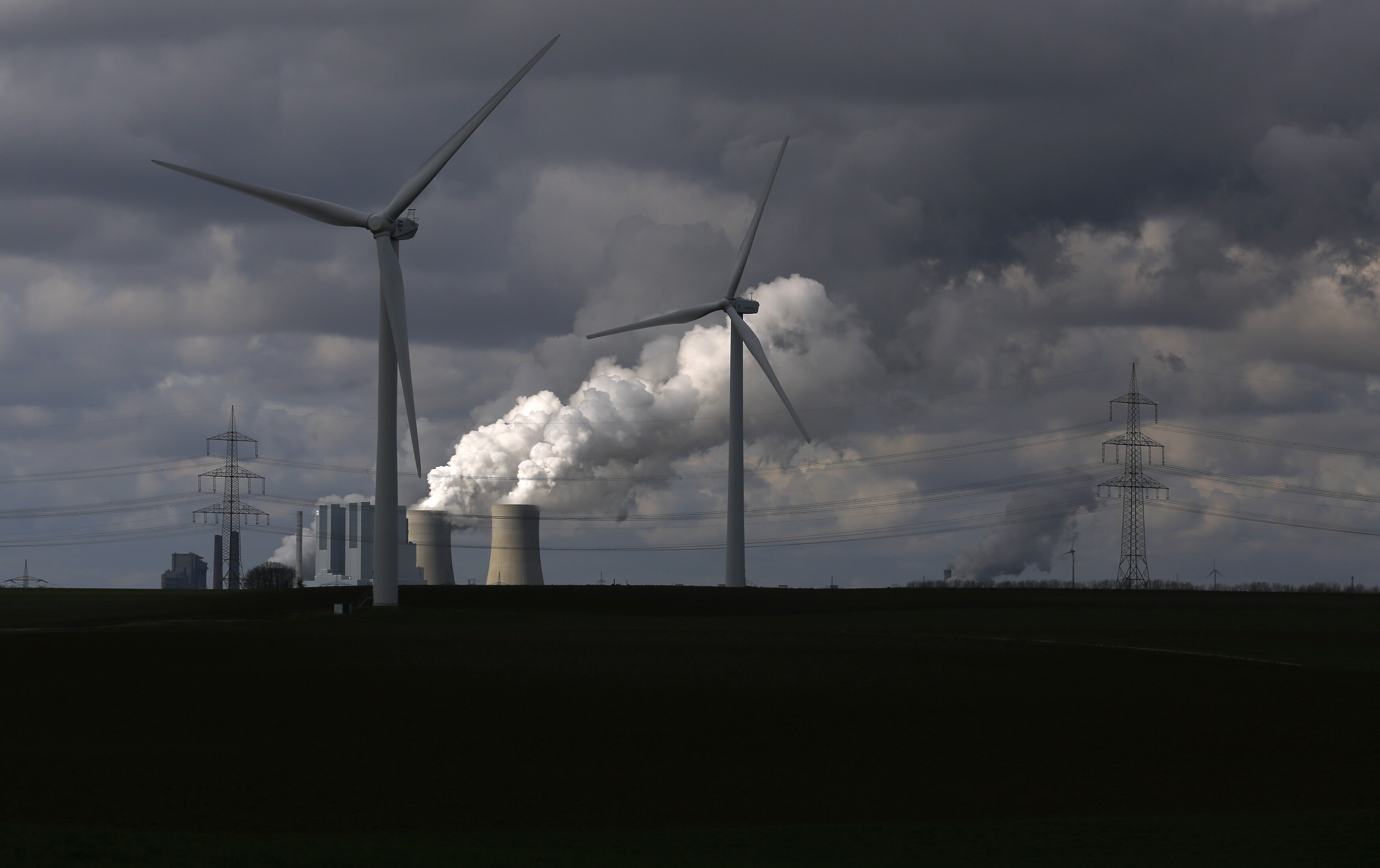 Wind turbines are seen in front of a coal power plant of German utility RWE Power near the western town of Neurath February 28, 2014. 