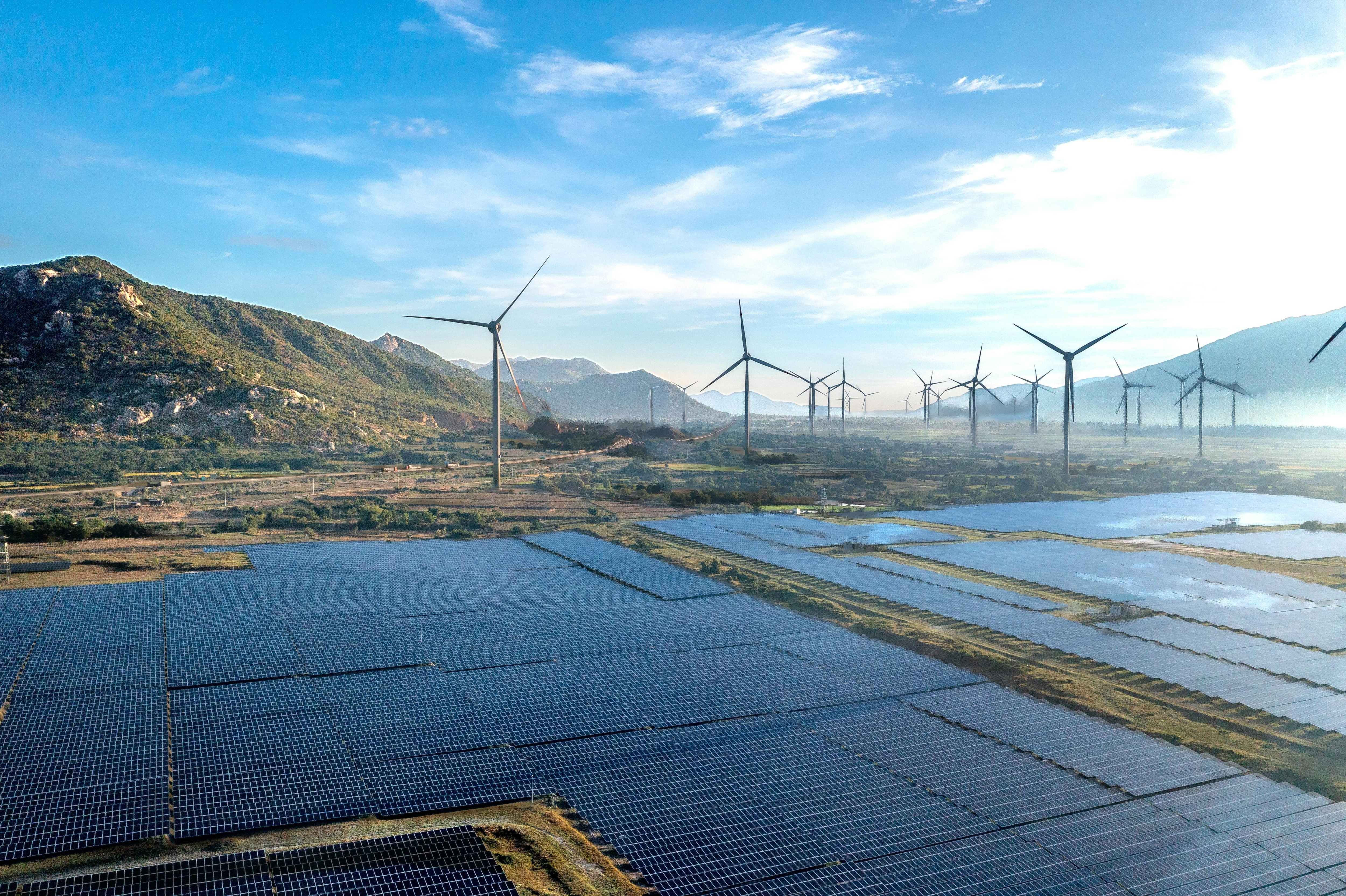 Wind turbines and solar panels are seen across the horizon.