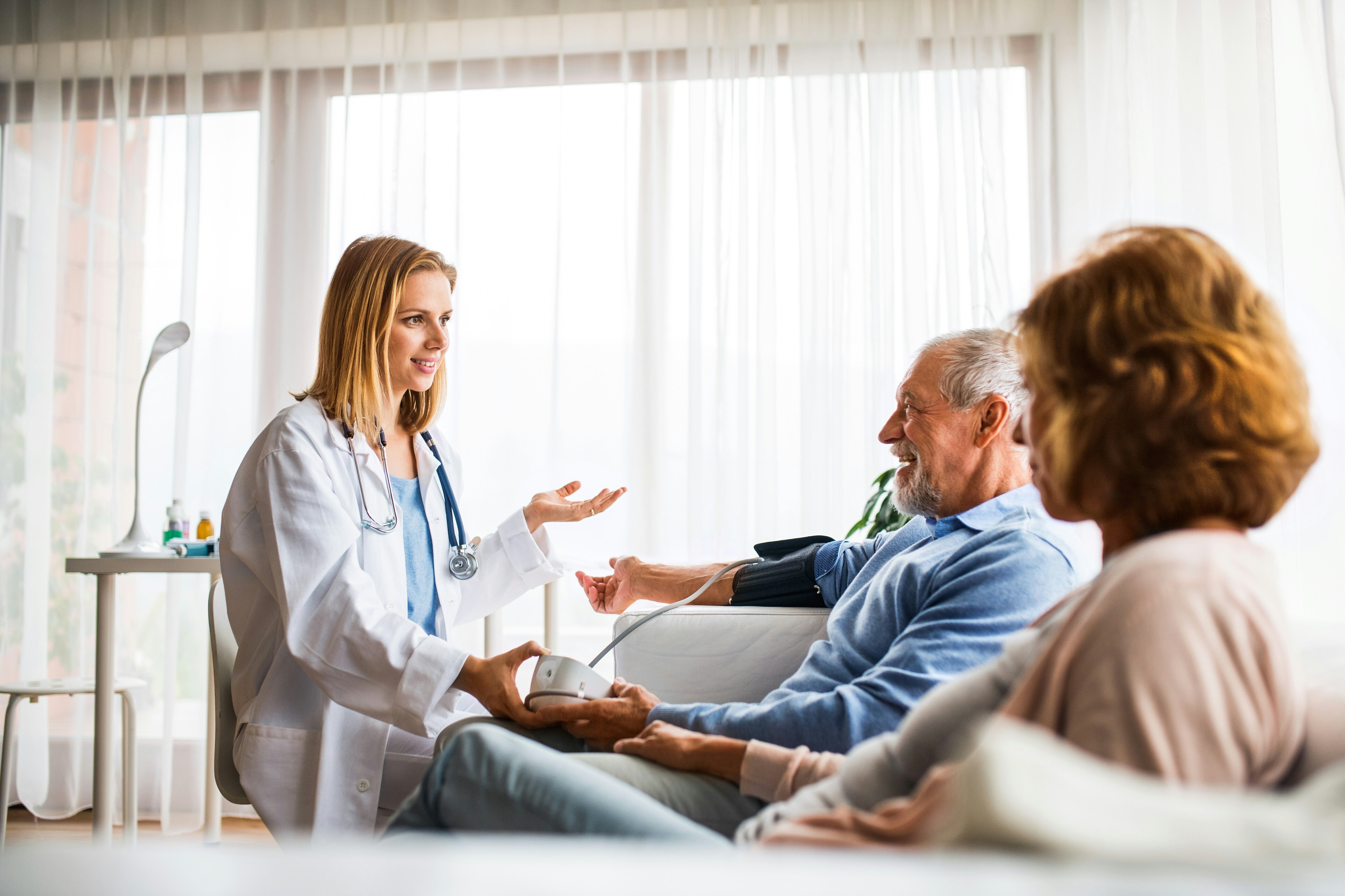 Doctor with man and woman; blood pressure check; hospital discharge