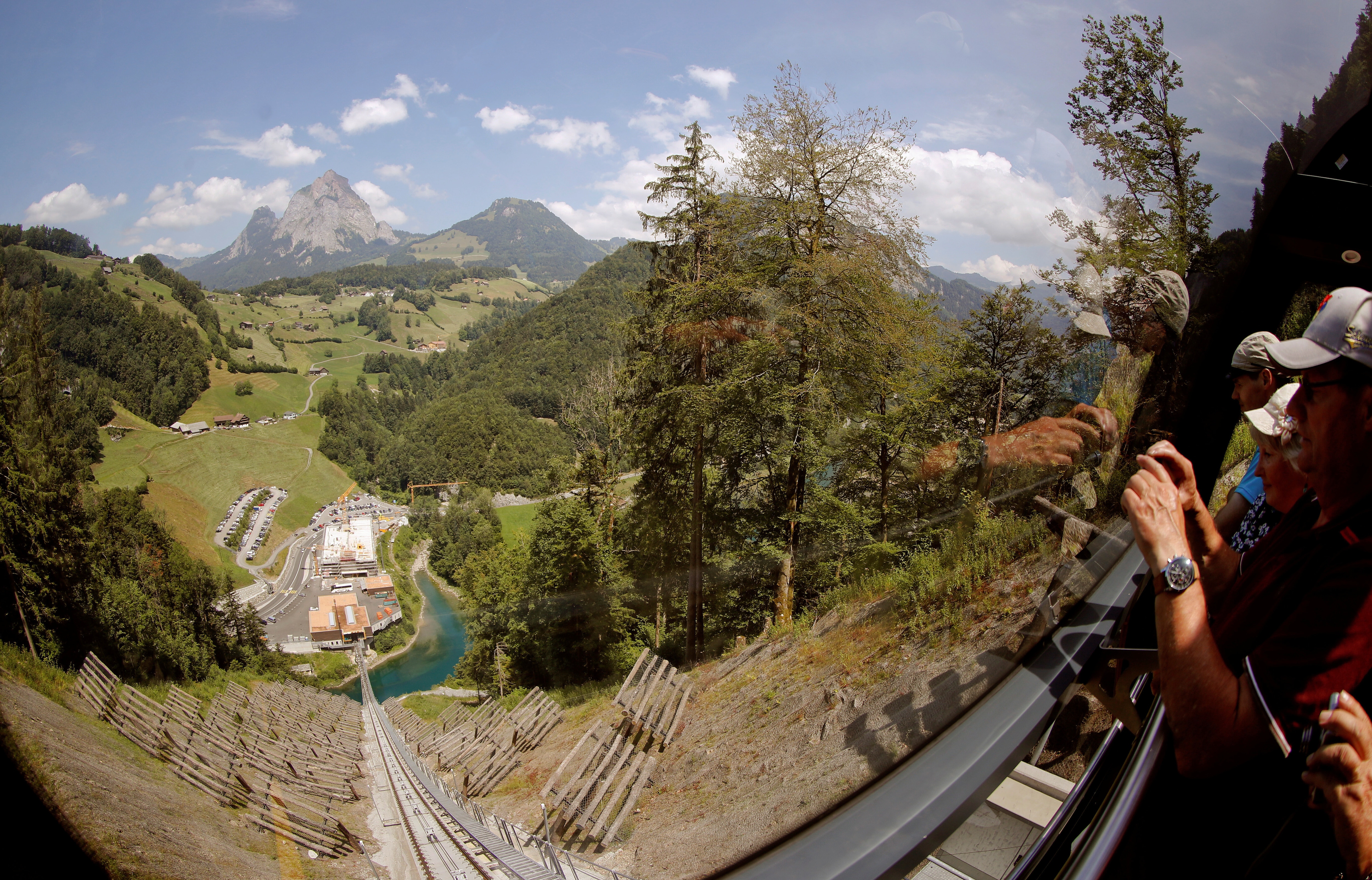 Mount Grosser Mythen is seen in the background as passengers watch through a window while riding down with the Stoosbahnen funicular near the village of Stoos, Switzerland.
