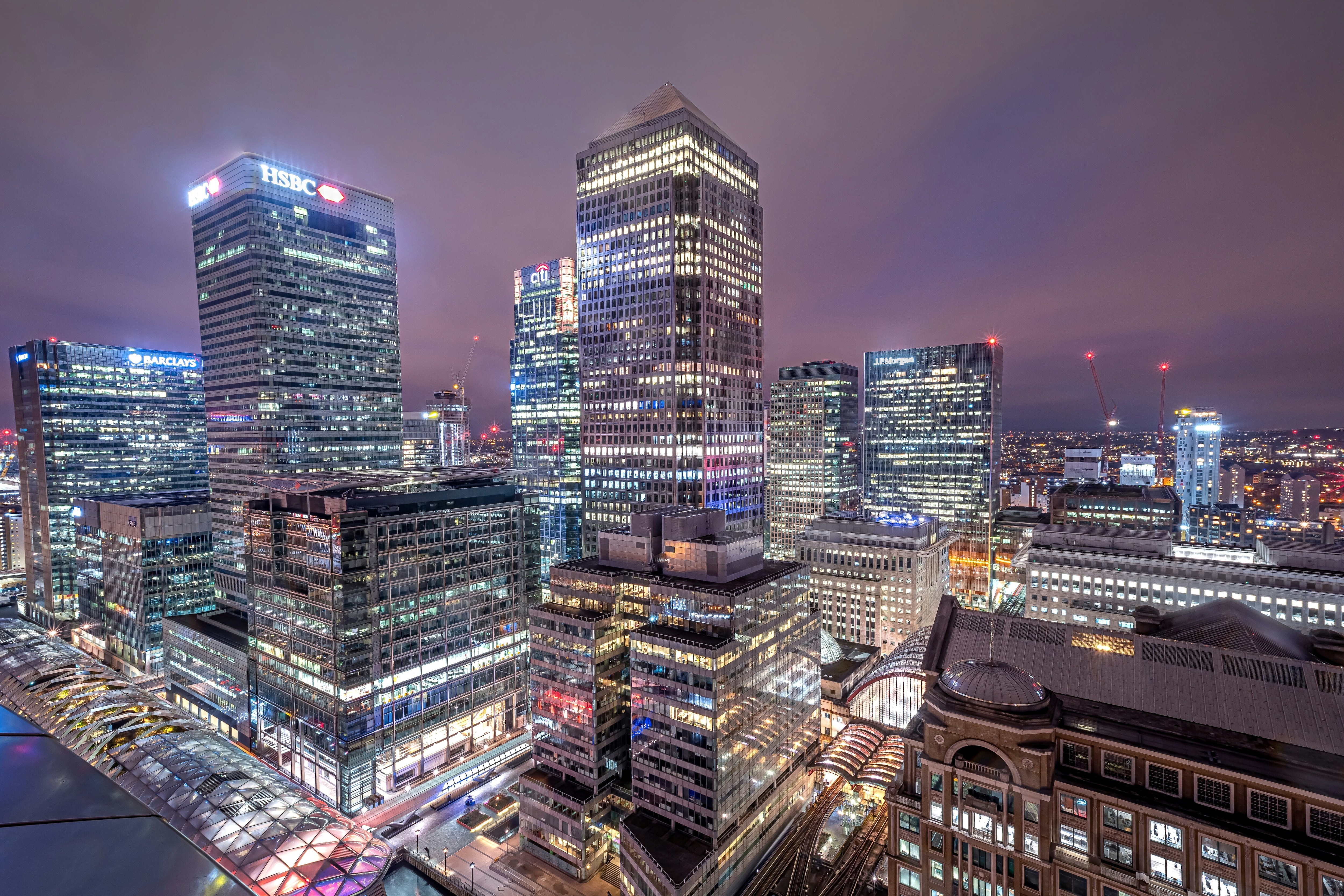 A night view of the illuminated skyscrapers of Canary Wharf in London's financial district.