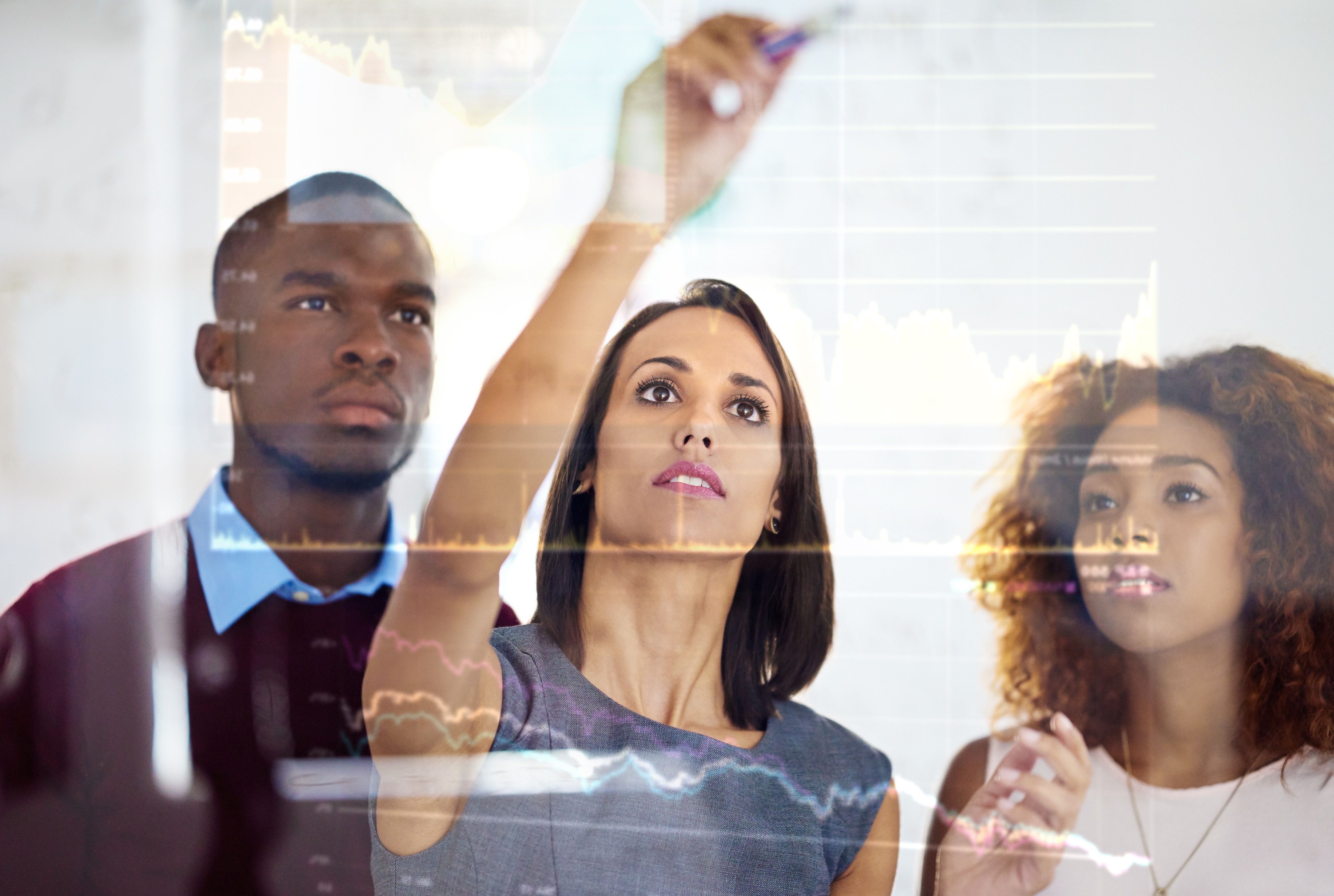 Shot of a group of business colleagues using a digital interface while standing in a modern office; AI-powered platforms