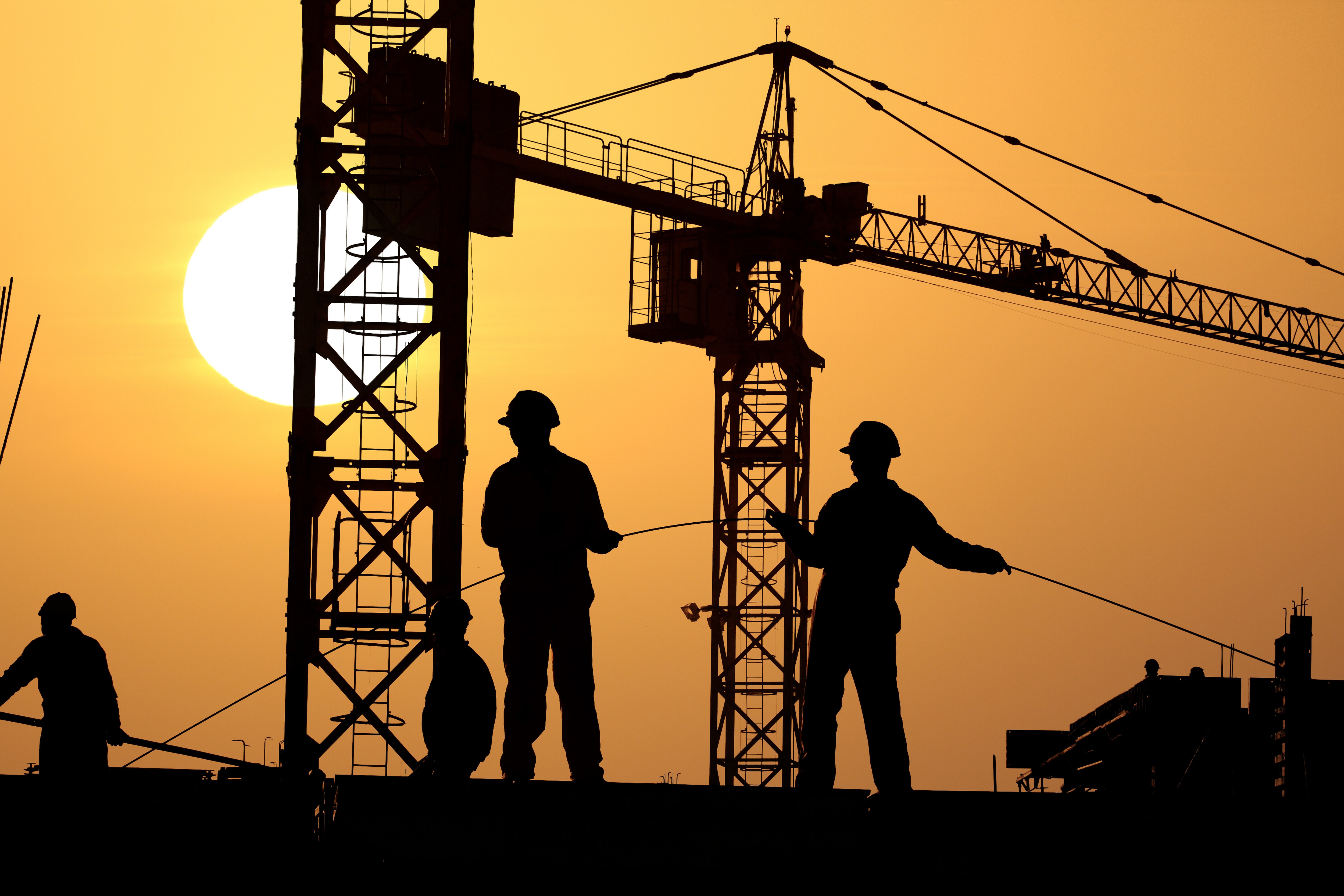 Building; infrastructure finance; sunrise behind a construction site. 