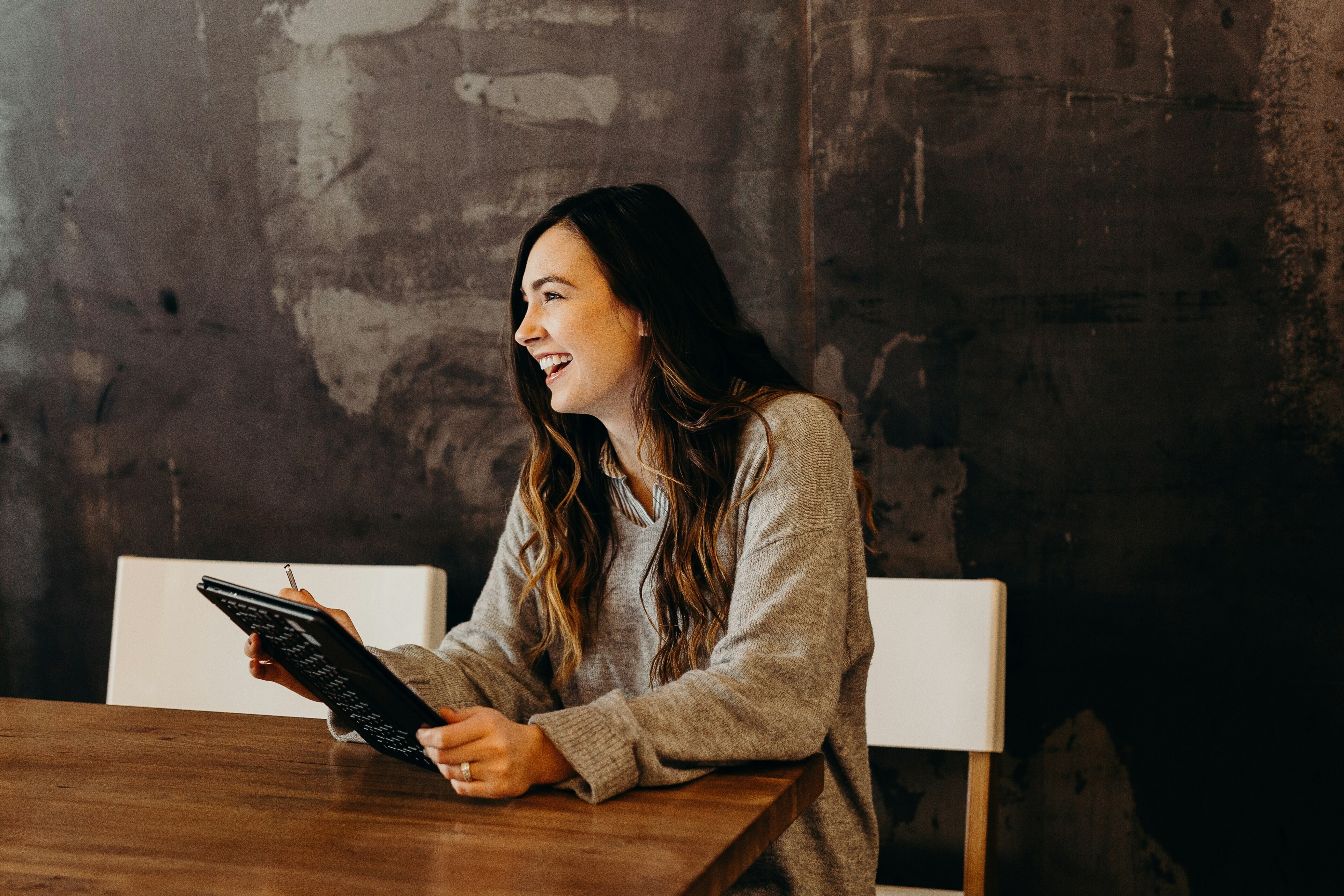 A picture of a happy female employee with an ipad: Business AI can free up time for employees, teams and organizations