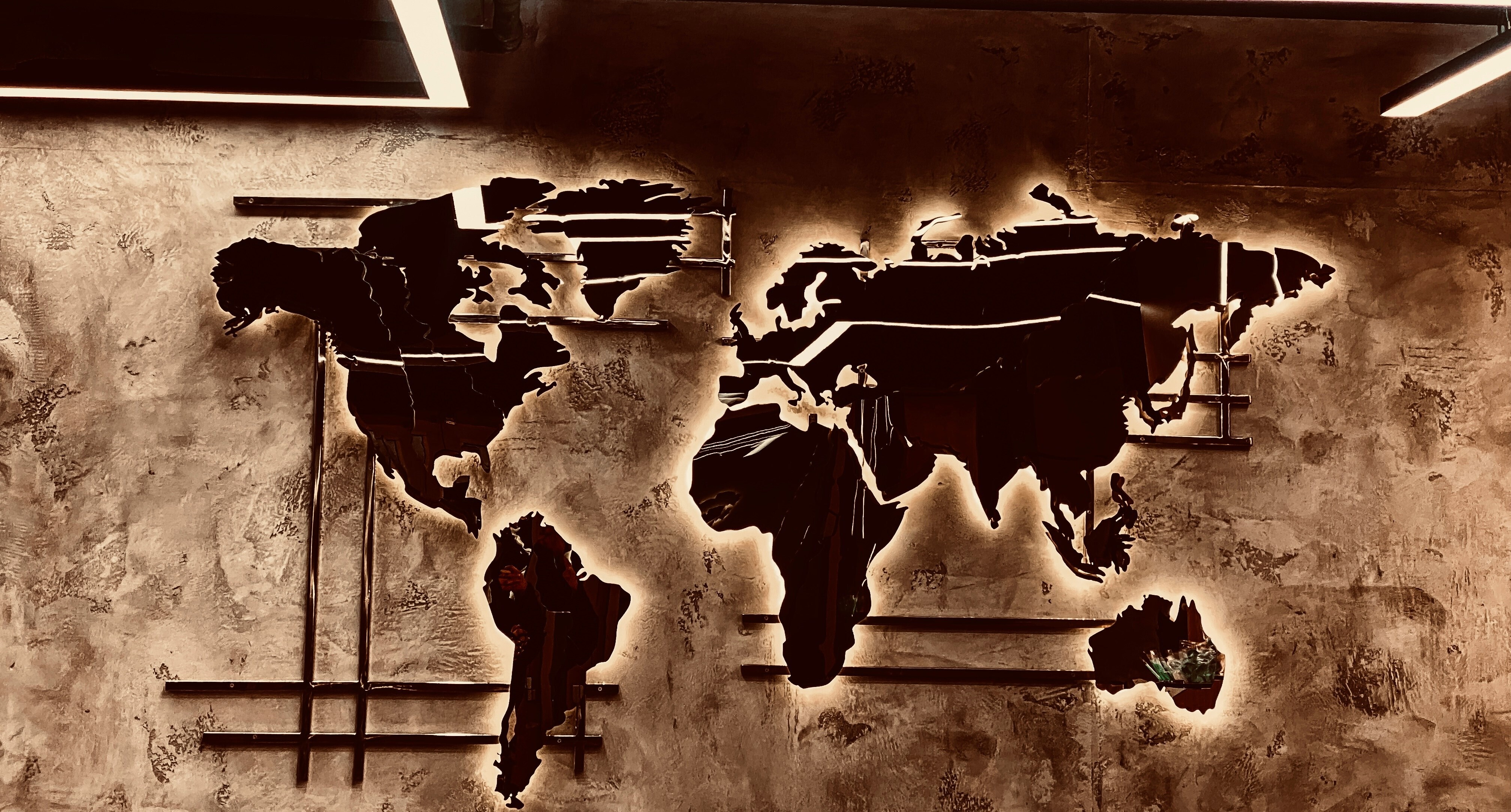 A world map metal structure on a wall: Geopolitics both impacts and can be shaped by companies