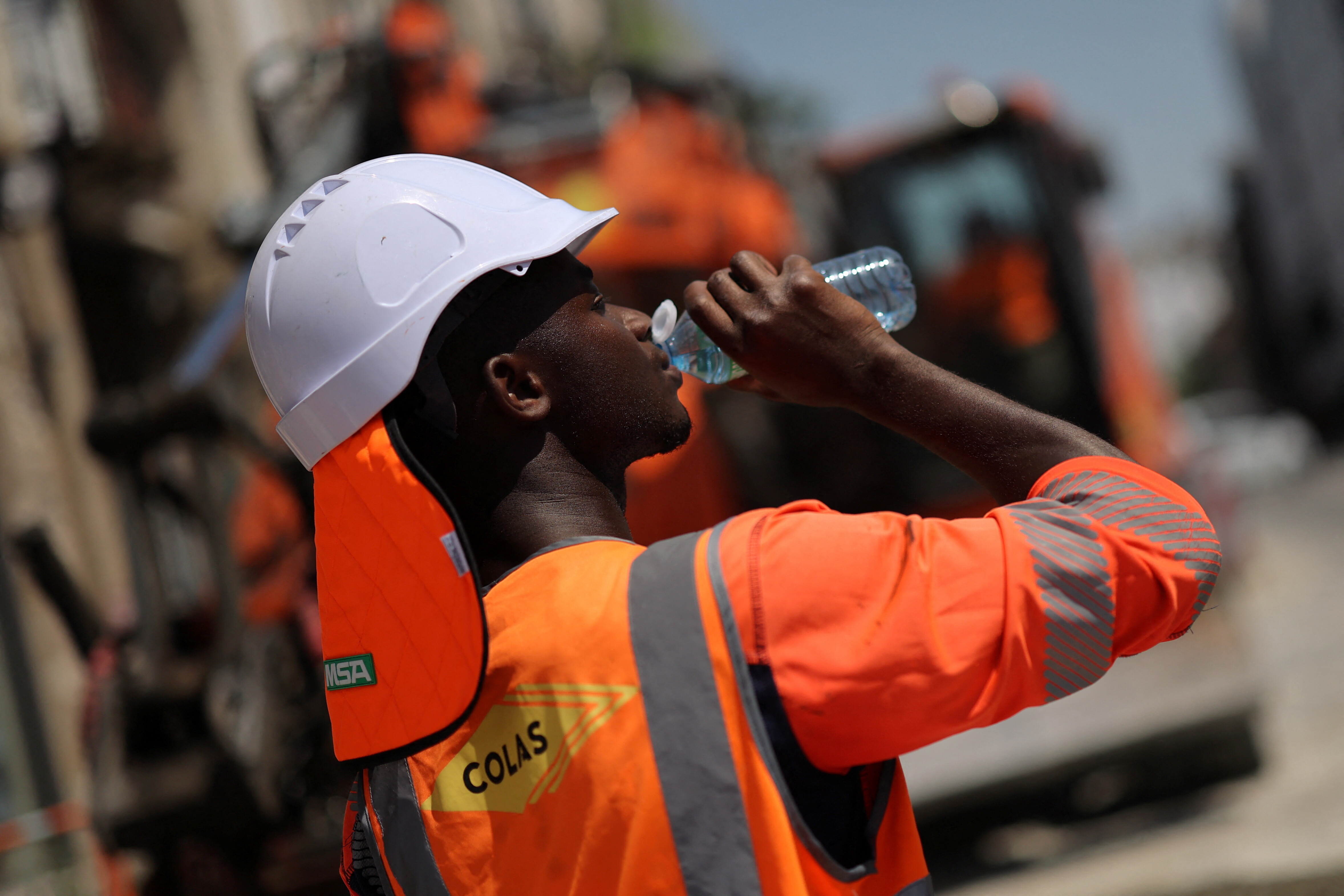 A worker drinks water on a construction site, on a warm and sunny day in Nantes as a heatwave hits France, June 20, 2025.