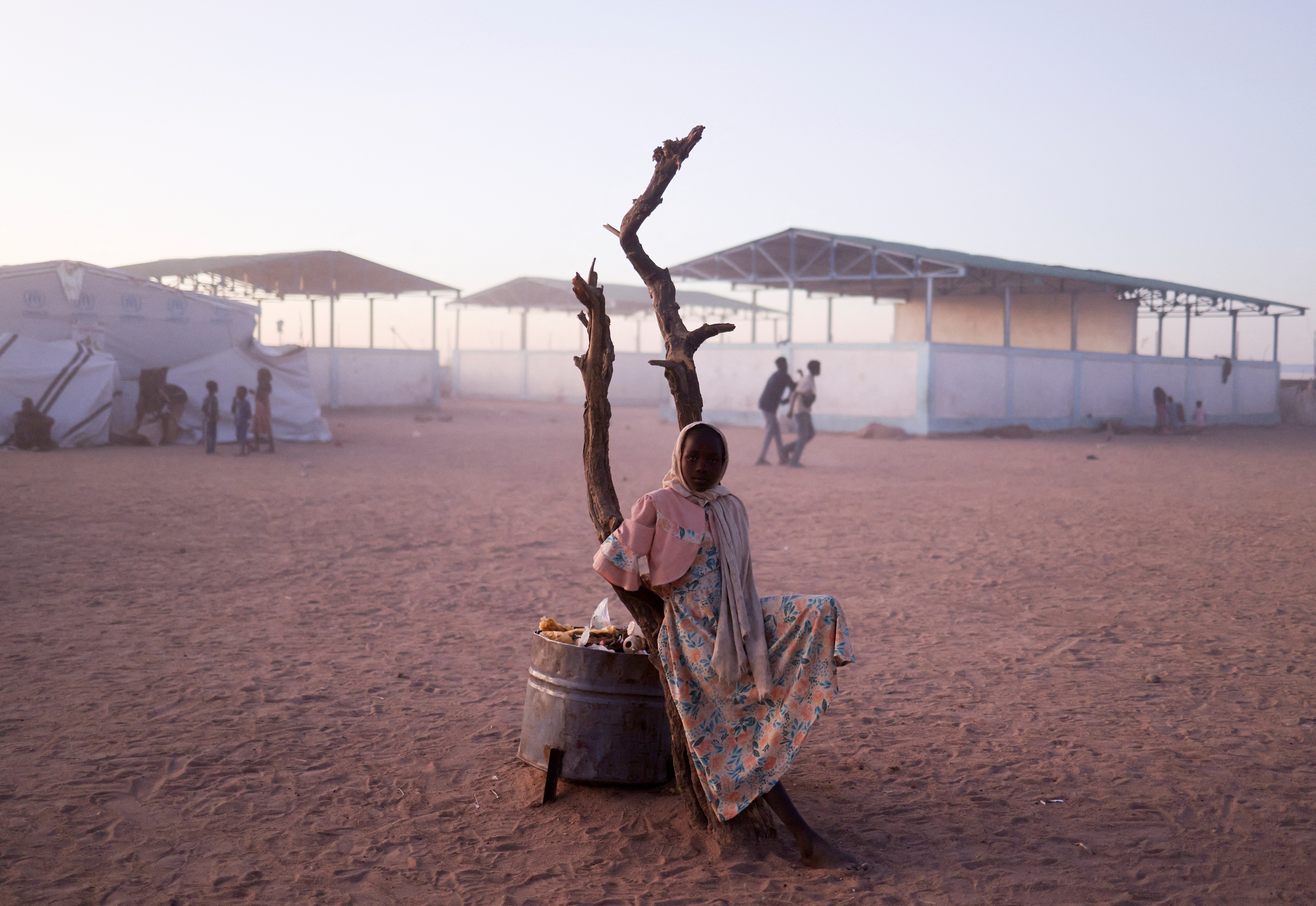 A Sudanese refugee girl from al-Fashir rests next to a burnt tree in the middle of the Tine transit camp, amid the conflict between the paramilitary Rapid Support Forces (RSF) and the Sudanese army, in eastern Chad, November 23, 2025. REUTERS/Amr Abdallah Dalsh TPX IMAGES OF THE DAY