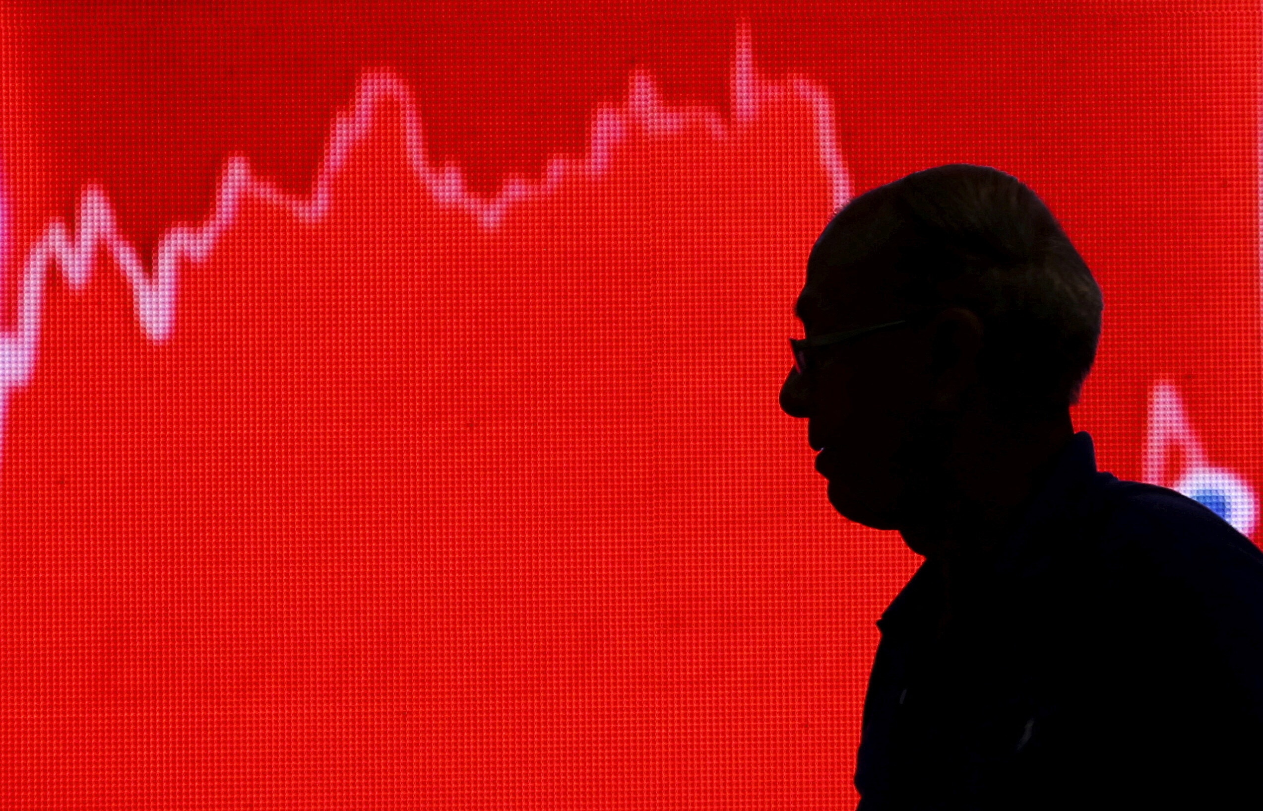 FILE PHOTO: A man looks at a screen displaying news of markets update inside the Bombay Stock Exchange building in Mumbai, India, February 11, 2016. REUTERS/Danish Siddiqui/File Photo