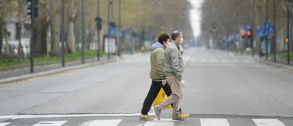 People walk in an empty street, during a lockdown against the spread of coronavirus disease (COVID-19) in Milan, Italy March 22, 2020. REUTERS/Daniele Mascolo - RC2ZOF9RNG6L