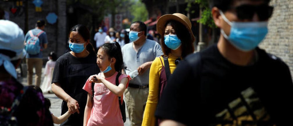 People wearing face masks visit Gubei Water Town on the first day of the five-day Labour Day holiday, following the coronavirus disease (COVID-19) outbreak, on the outskirts of Beijing, China, May 1, 2020. REUTERS/Carlos Garcia Rawlins