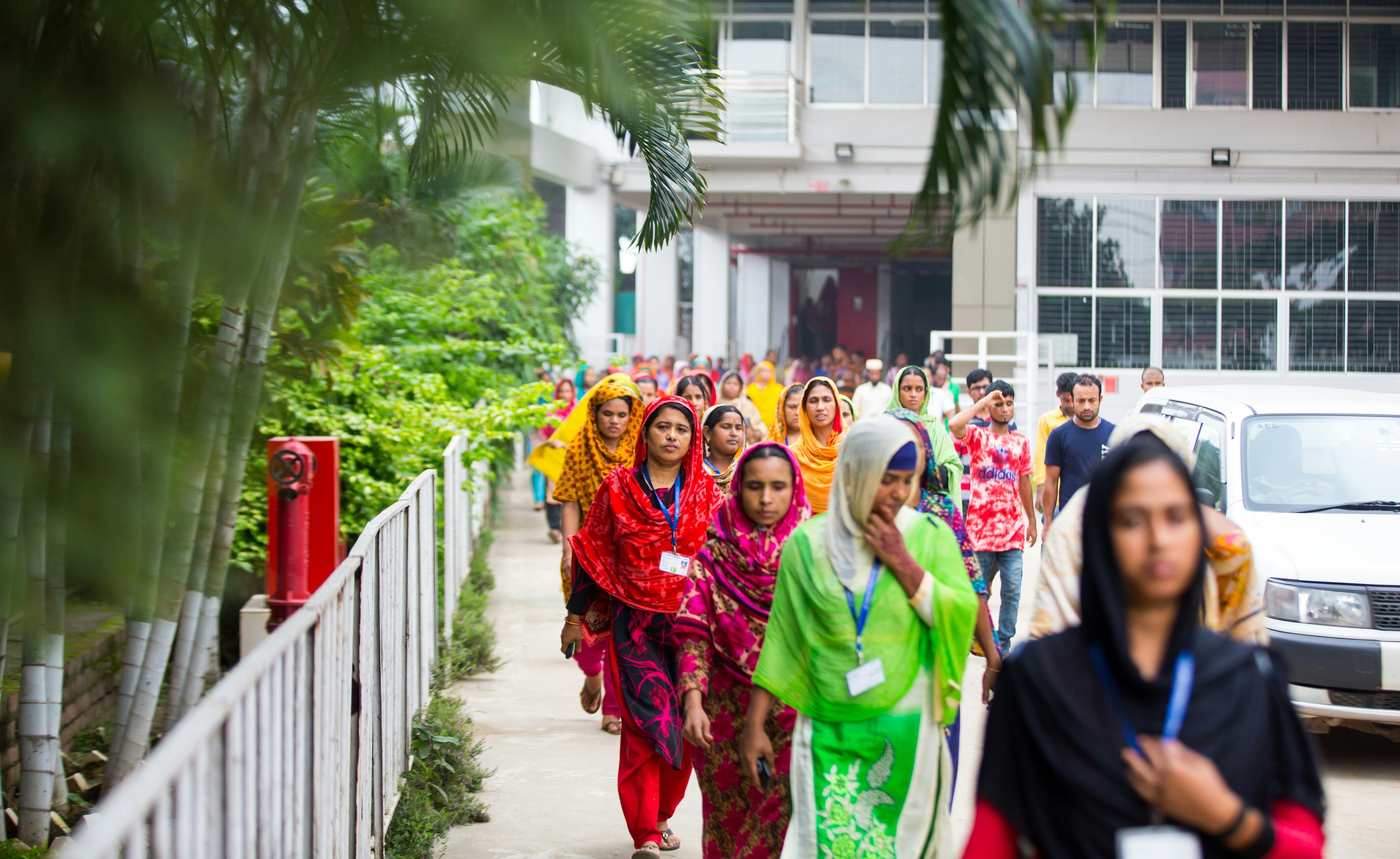 Women in colourful traditional clothing walking out of a hospital in Bangladesh: Noncommunicable diseases in Bangladesh can be tackled through coordinated primary health care