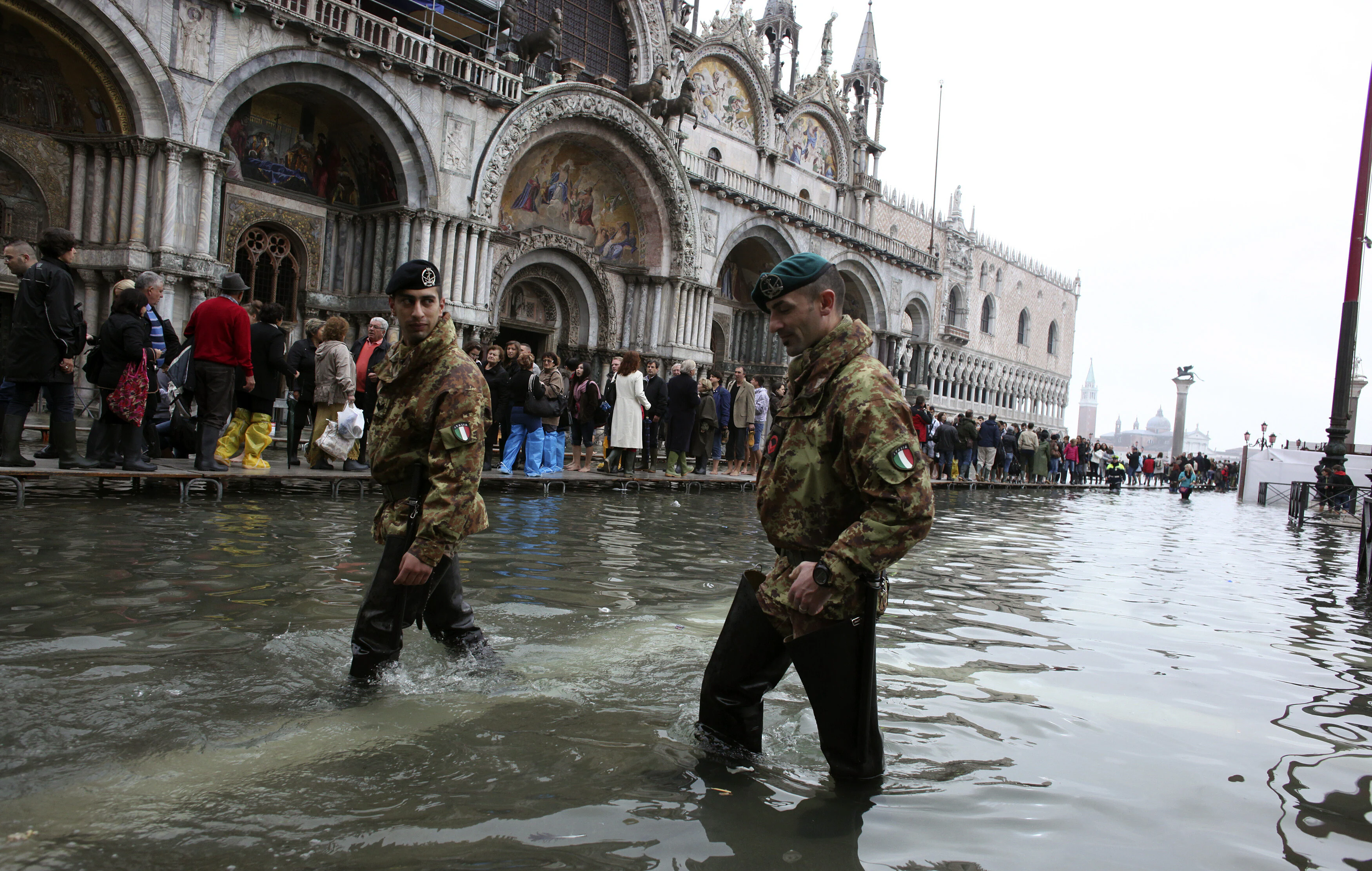 Soldados del ejército italiano patrullan la Plaza de San Marcos durante un período de marea alta estacional en Venecia, el 27 de octubre de 2012. El nivel del agua en la ciudad de los canales subió 127 cm (50 pulgadas) por encima del nivel normal, según el instituto de monitoreo: las capacidades de defensa europeas deberían incluir tecnologías de doble uso con respuesta climática.