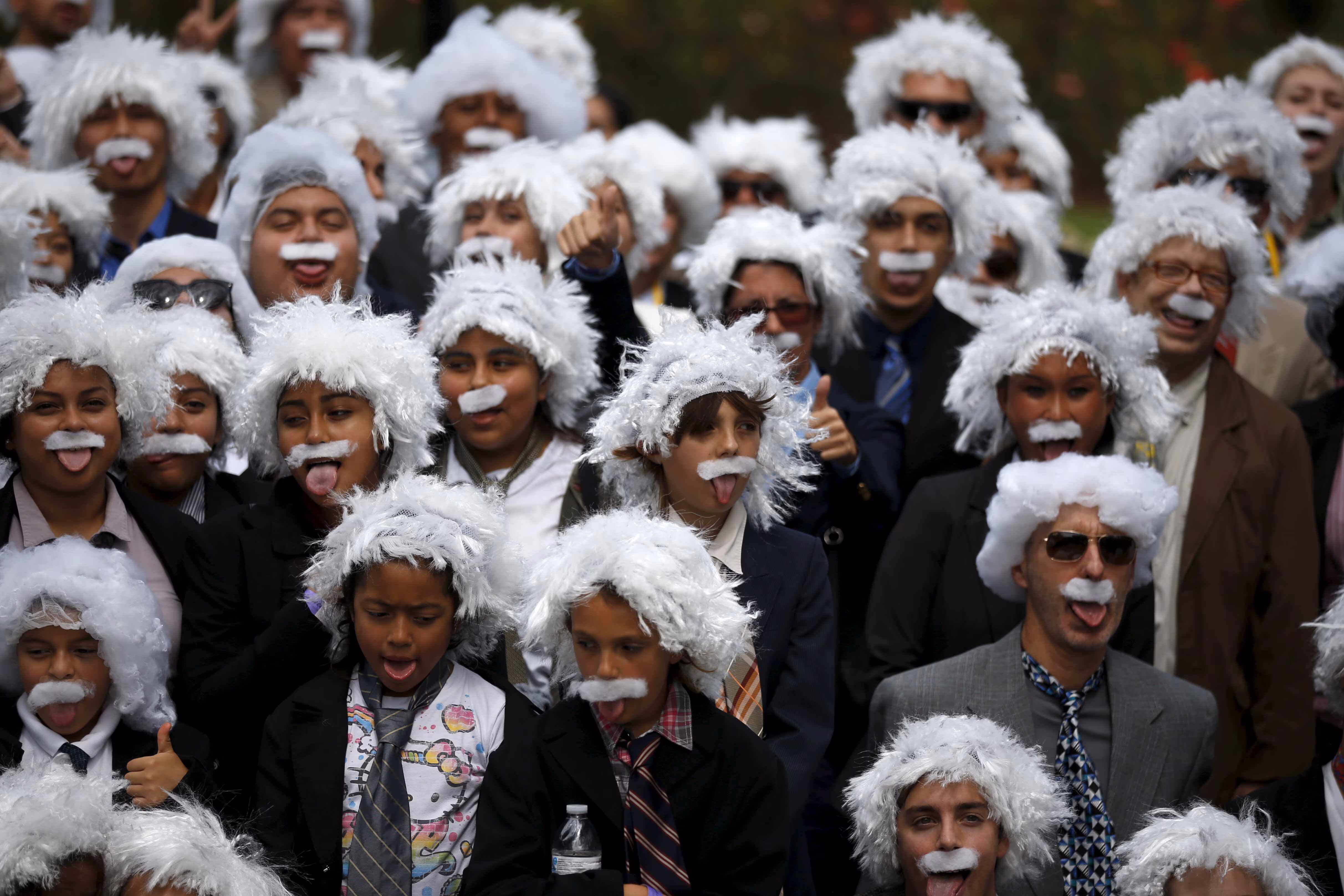 Un grupo diverso de niños con pelucas y bigotes de algodón.