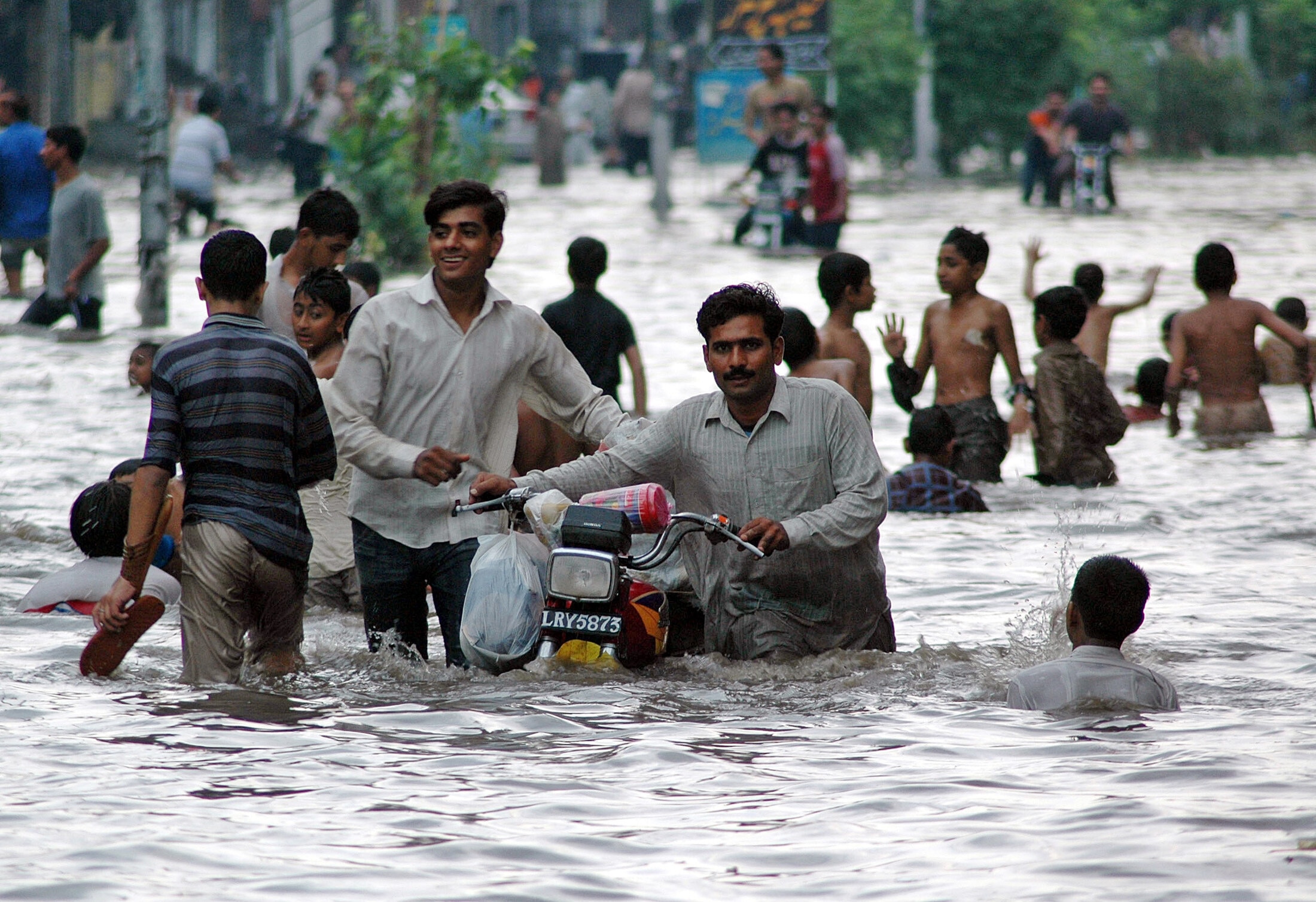 People walk through flooded streets after a heavy downpour in Lahore July 23, 2006: As Pakistan's population continues to grow, administrative reform becomes an ongoing concern