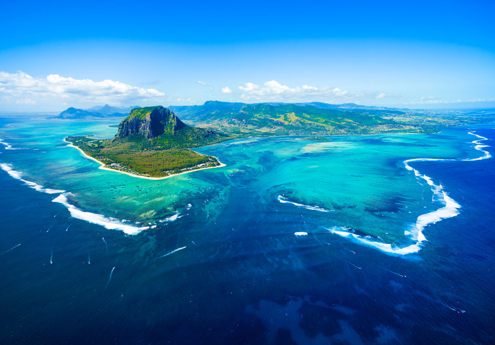 Una isla con picos verdes en el océano azul.