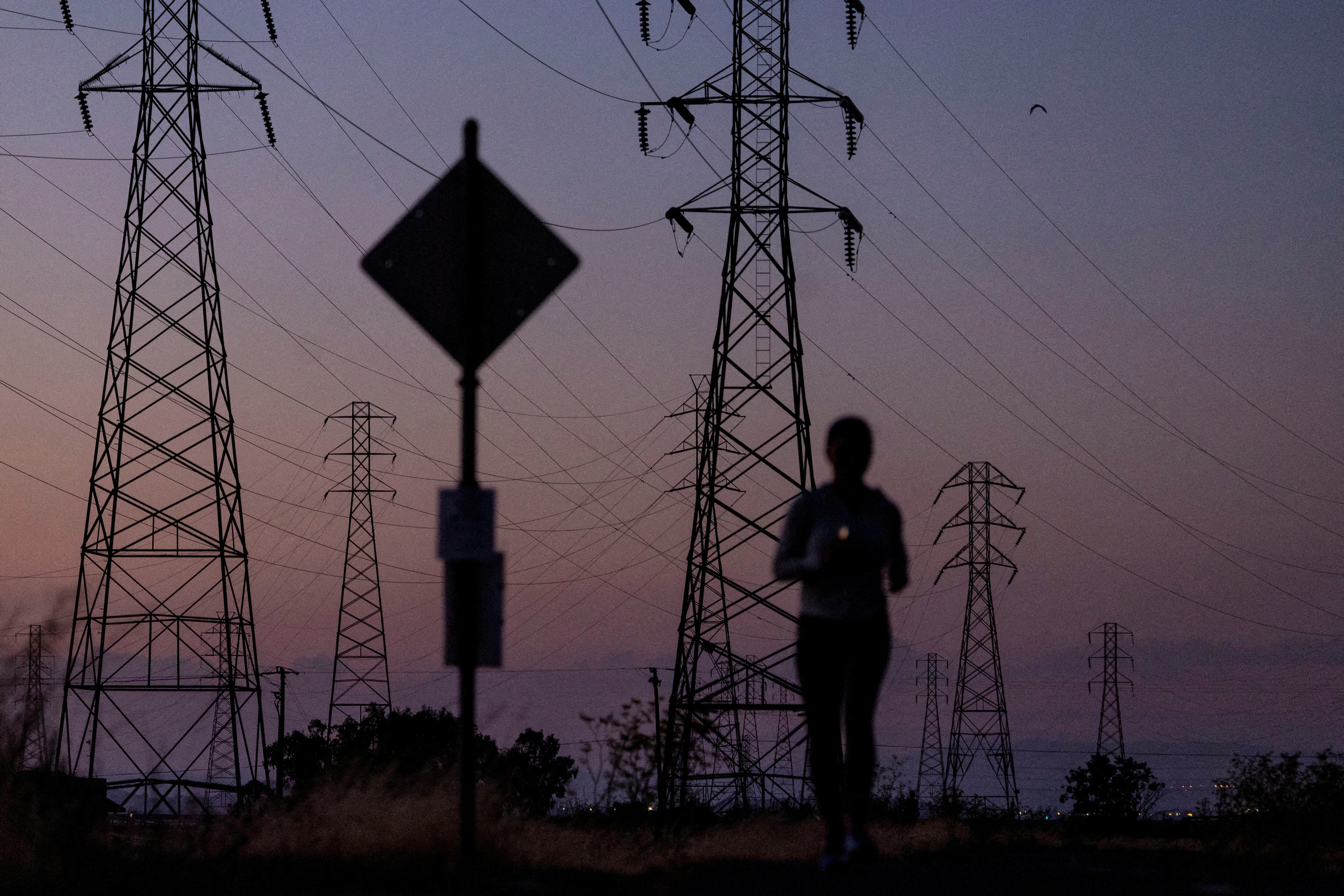 Woman jogging near power lines during a California heat wave.