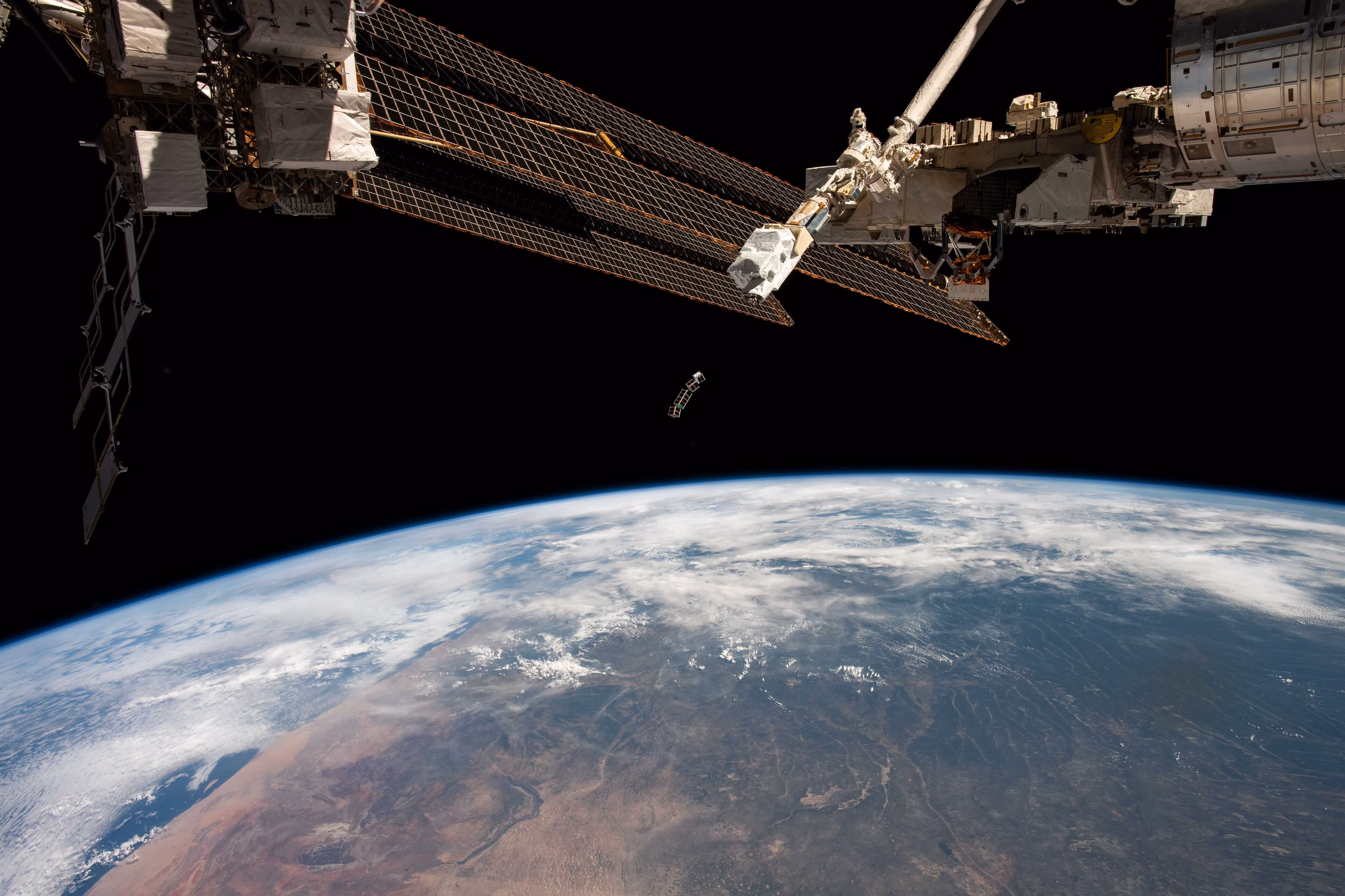 La Tierra vista desde el espacio con una vista parcial de un satélite en órbita.