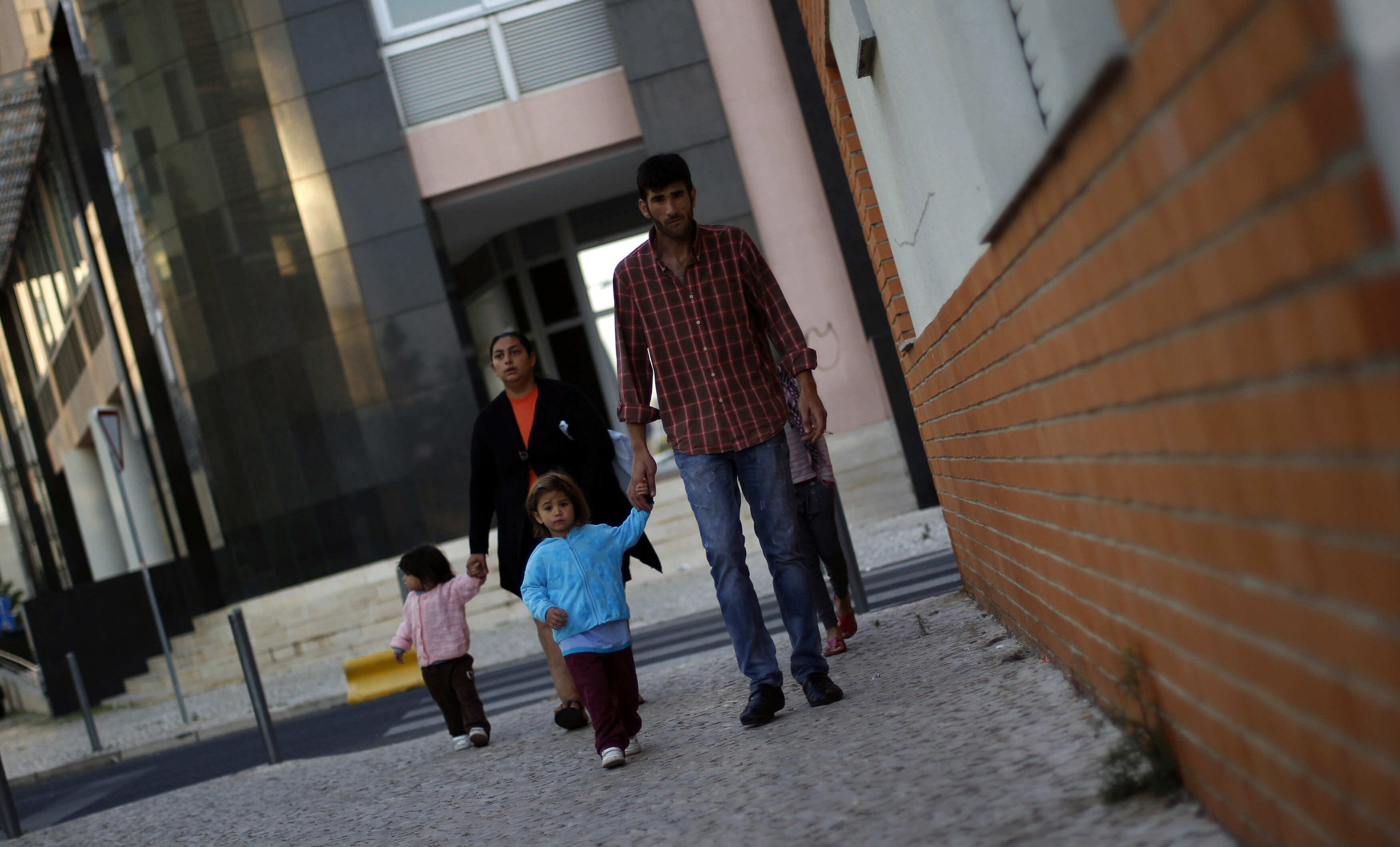 Mateus Silva, 25 and unemployed, brings his daughters to school in the Nossa Senhora de Fatima neighborhood in Lisbon October 19, 2011. Silva has been living in the caravan with his wife, Leonor and their two daughters for 18 months, as they have no money to rent an apartment: Banking and finance were founded on mutual aid