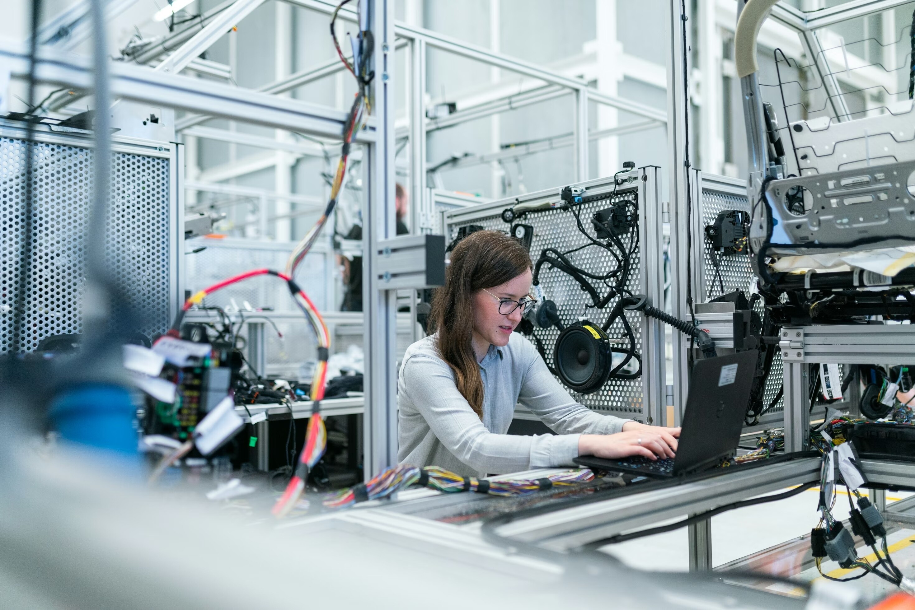 A woman is on a computer surrounding by gear: The third MINDS cohort demonstrate how AI is being embedded in production systems and producing tangible results