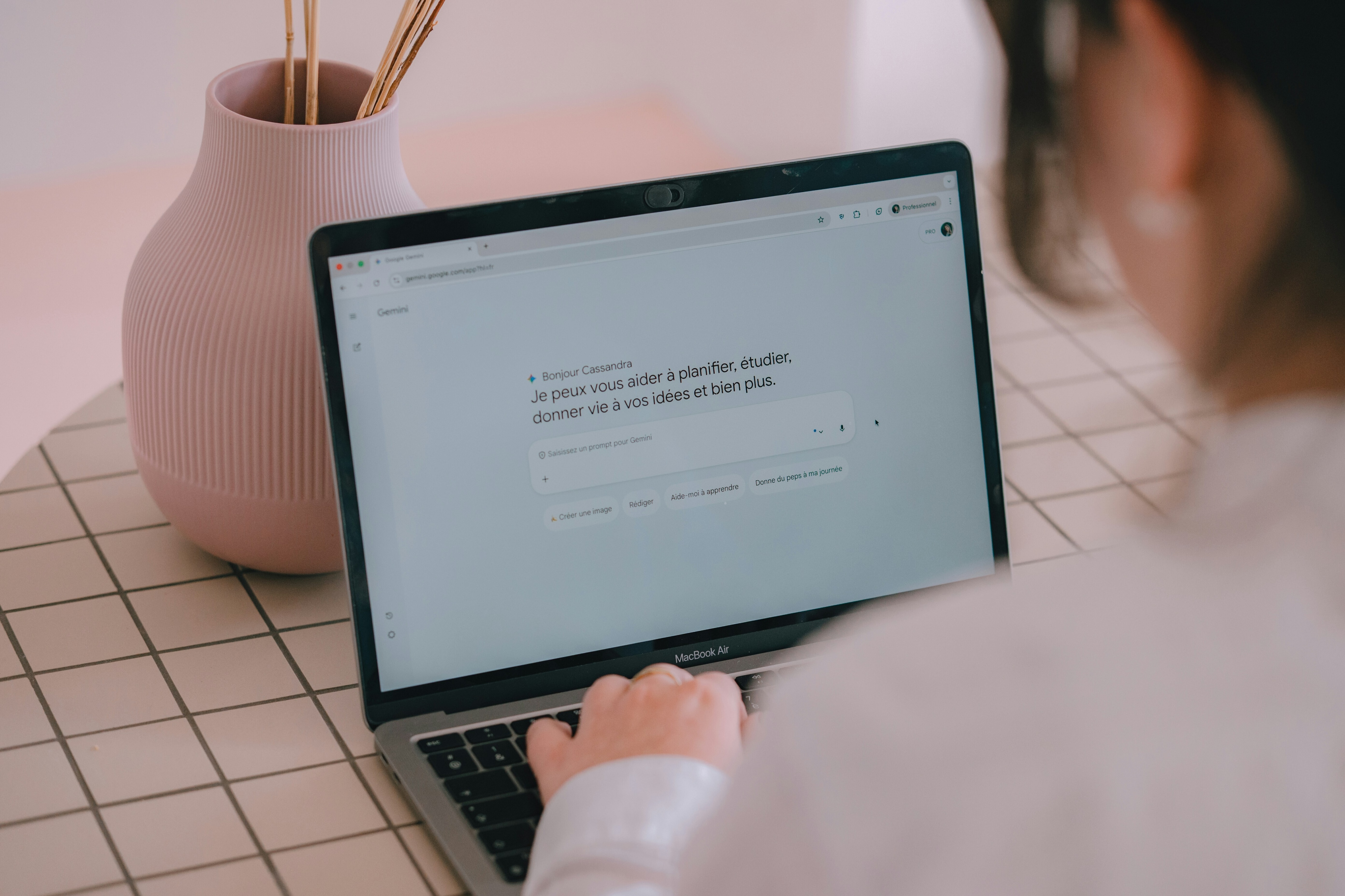 A woman tupes a prompt into a large language model programme with pink vase and chequered table cloth in the background: When people repeatedly outsource difficult and sensitive communications to AI, it creates an empathy gap in the workforce