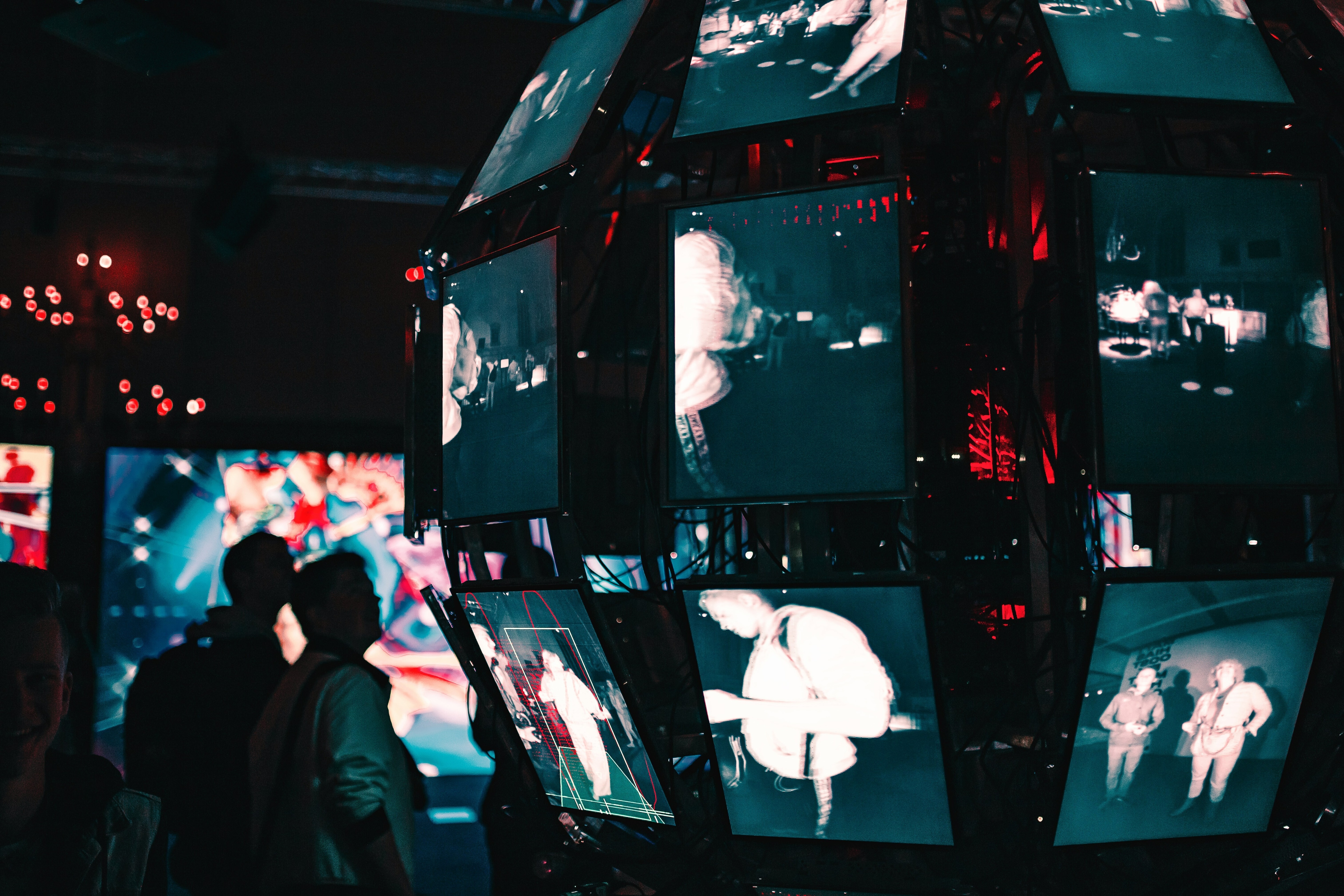 People an an exhibition watch themselves captured on screens, reflecting the amount of data captured and created.