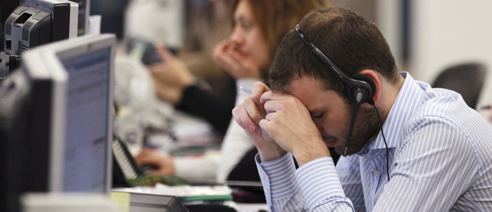 A worker on the IG Group's trading floor looks away from his screens in the City of London, October 4, 2011. Britain's top share index fell sharply by midday on Tuesday as worries over the euro zone debt crisis and the sustainability of global growth prompted investors to cut positions in riskier assets such as banks and commodity stocks. REUTERS/Olivia Harris (BRITAIN - Tags: BUSINESS POLITICS) - RTR2S7IX