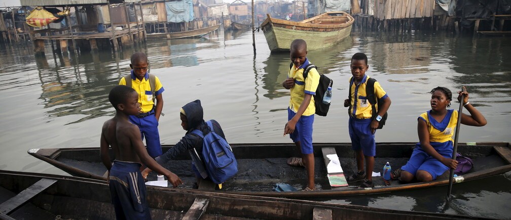 Students who attend a floating school travel on a canoe to school in the Makoko fishing community on the Lagos Lagoon, Nigeria February 29, 2016. In Makoko, a sprawling slum of Nigeria's megacity Lagos, a floating school capable of holding up to a hundred pupils has since November brought free education to the waterways known as the Venice of Lagos. It offers the chance of social mobility for youngsters who, like most of the city's 21 million inhabitants, lack a reliable electricity and water supply and whose water-based way of life is threatened by climate change as well as rapid urbanisation. REUTERS/Akintunde Akinleye SEARCH "THE WIDER IMAGE" FOR ALL STORIES  - GF10000333177