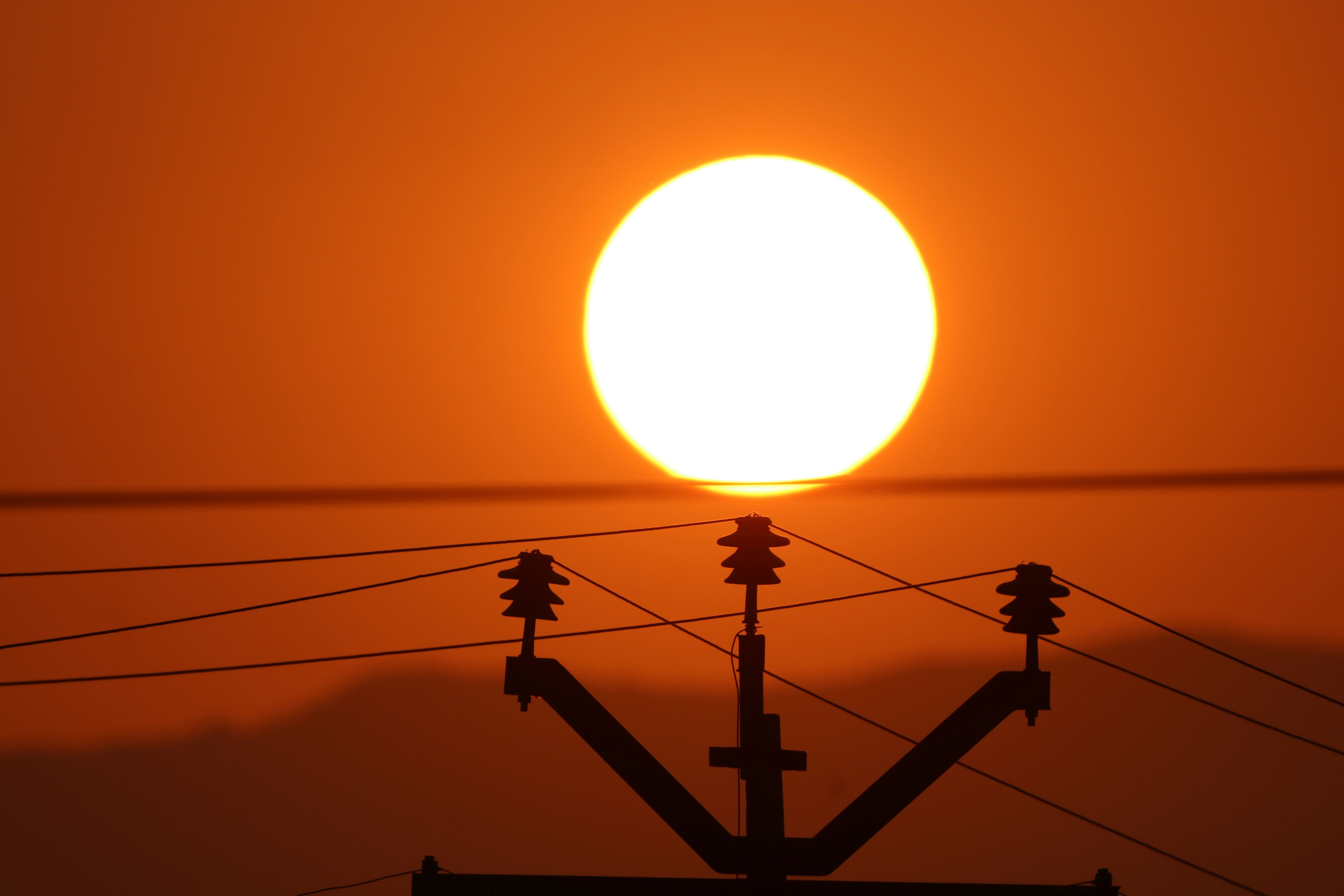 The sun sets behind a power line in Kodaikanal, Tamil Nadu, India.
