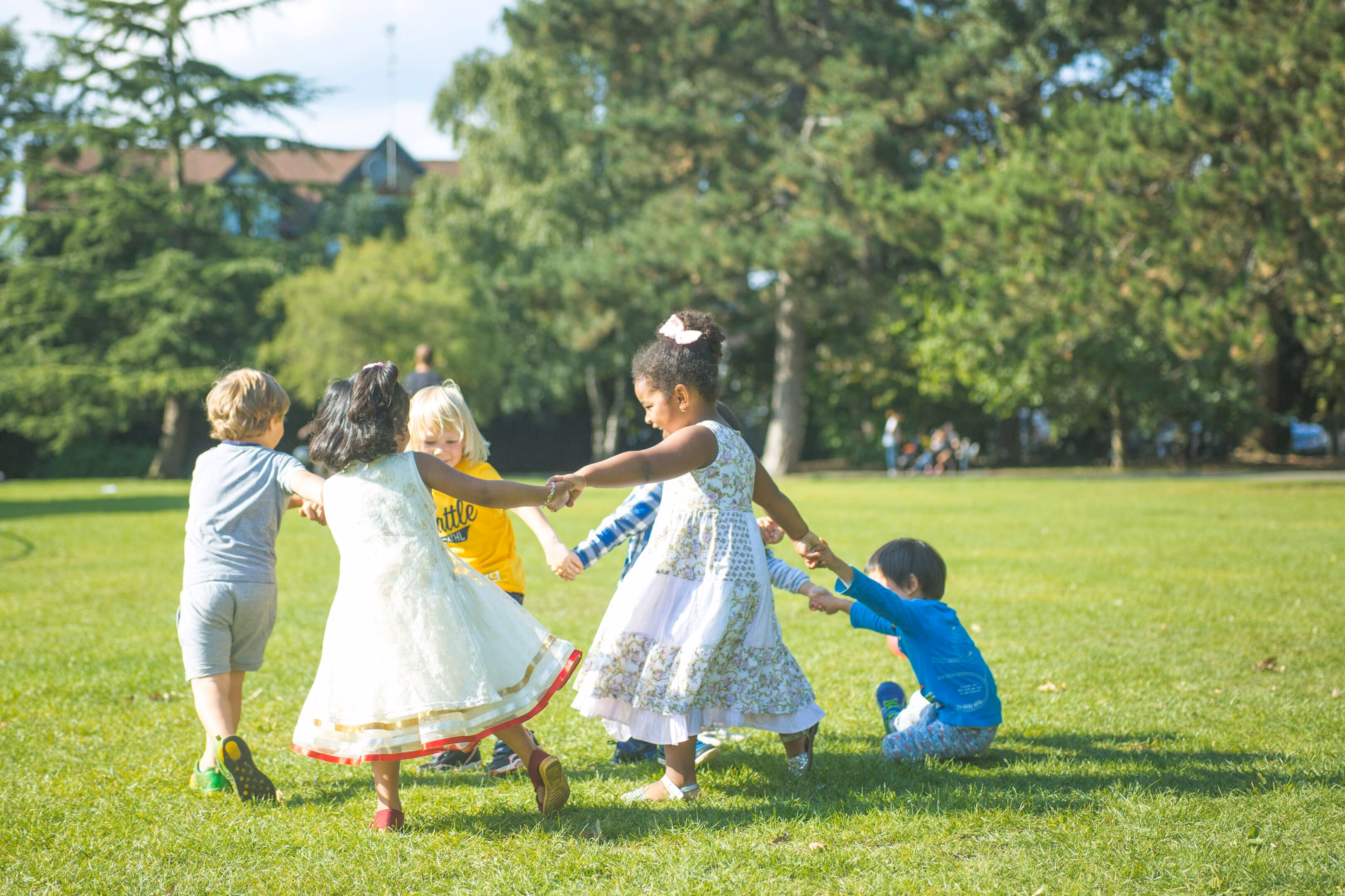 Niños jugando y bailando en círculo.