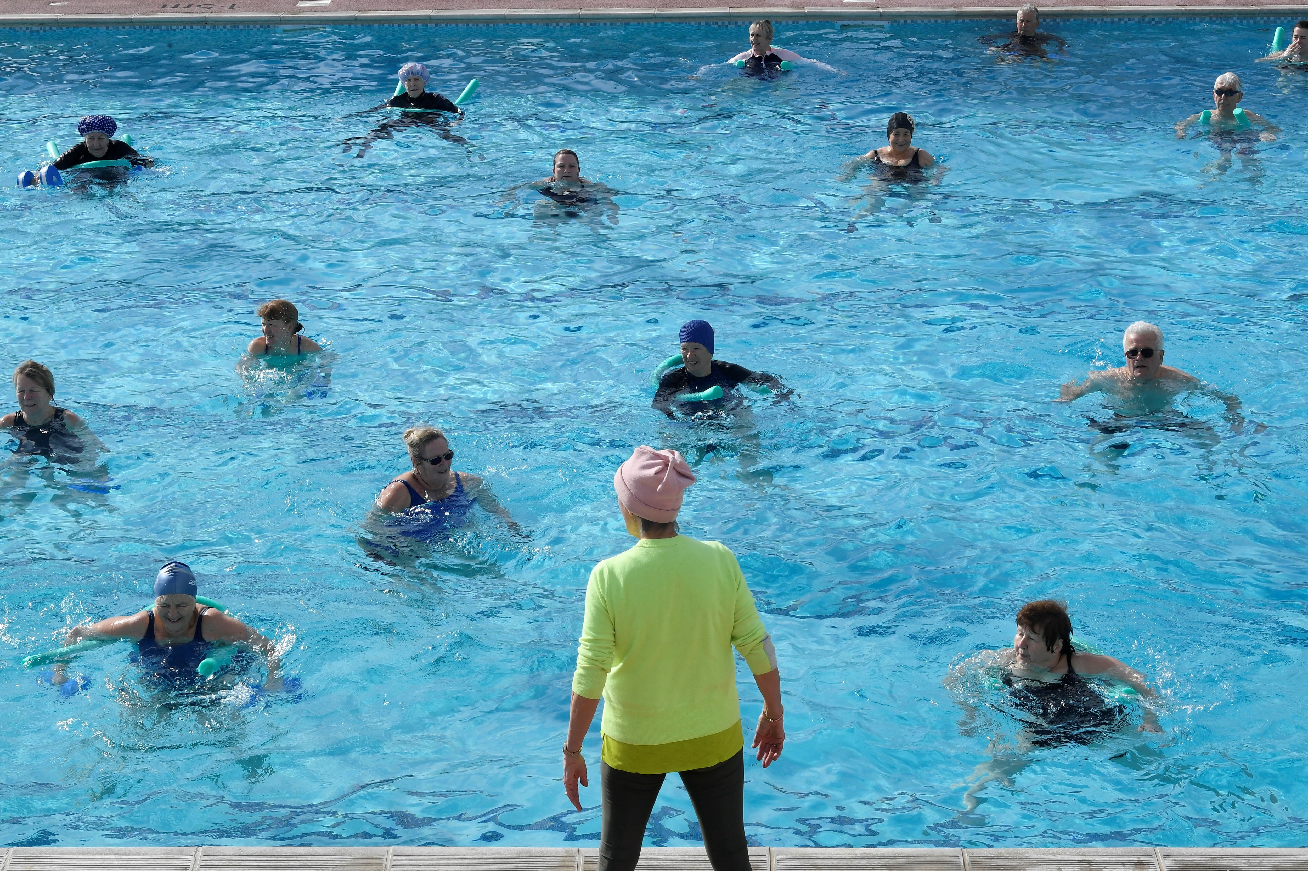 Swimmers take part in an aqua aerobics class in Hampton Lido on the first day that outdoor pools are open following the easing of lockdown restrictions, amid the spread of the coronavirus disease (COVID-19) pandemic in London, Britain, March 29, 2021. REUTERS/Toby Melville