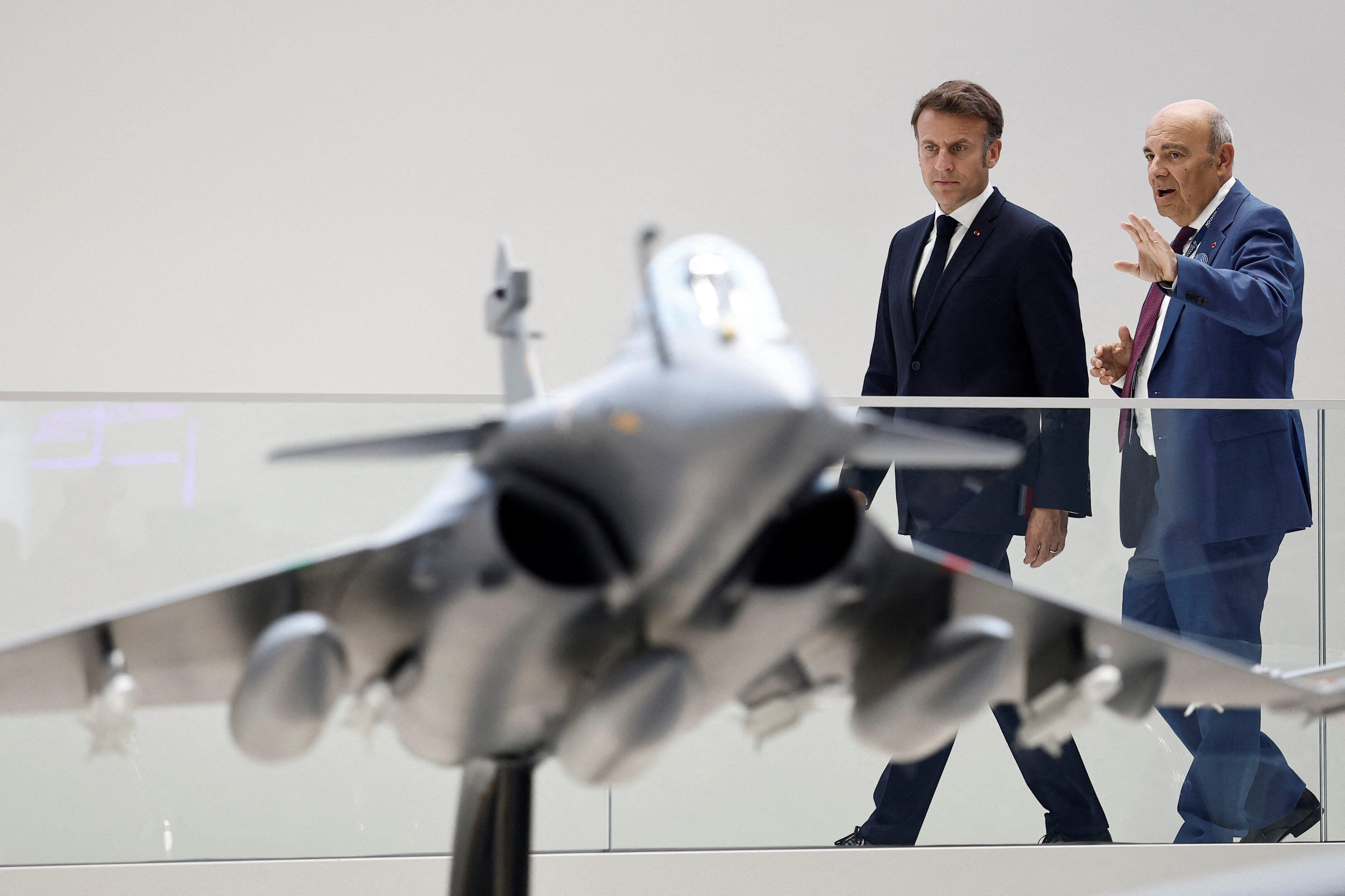 French President Emmanuel Macron listens to Eric Trappier, Chairman and Chief Executive Officer of Dassault Aviation, as they look at a display model of a Rafale fighter jet at the stand of aircraft manufacturer Dassault Aviation during a visit at the 55th International Paris Airshow at Le Bourget Airport near Paris, France, June 20, 2025: The Paris Air Show 2025 highlighted the industry's transition from ambition to implementation
