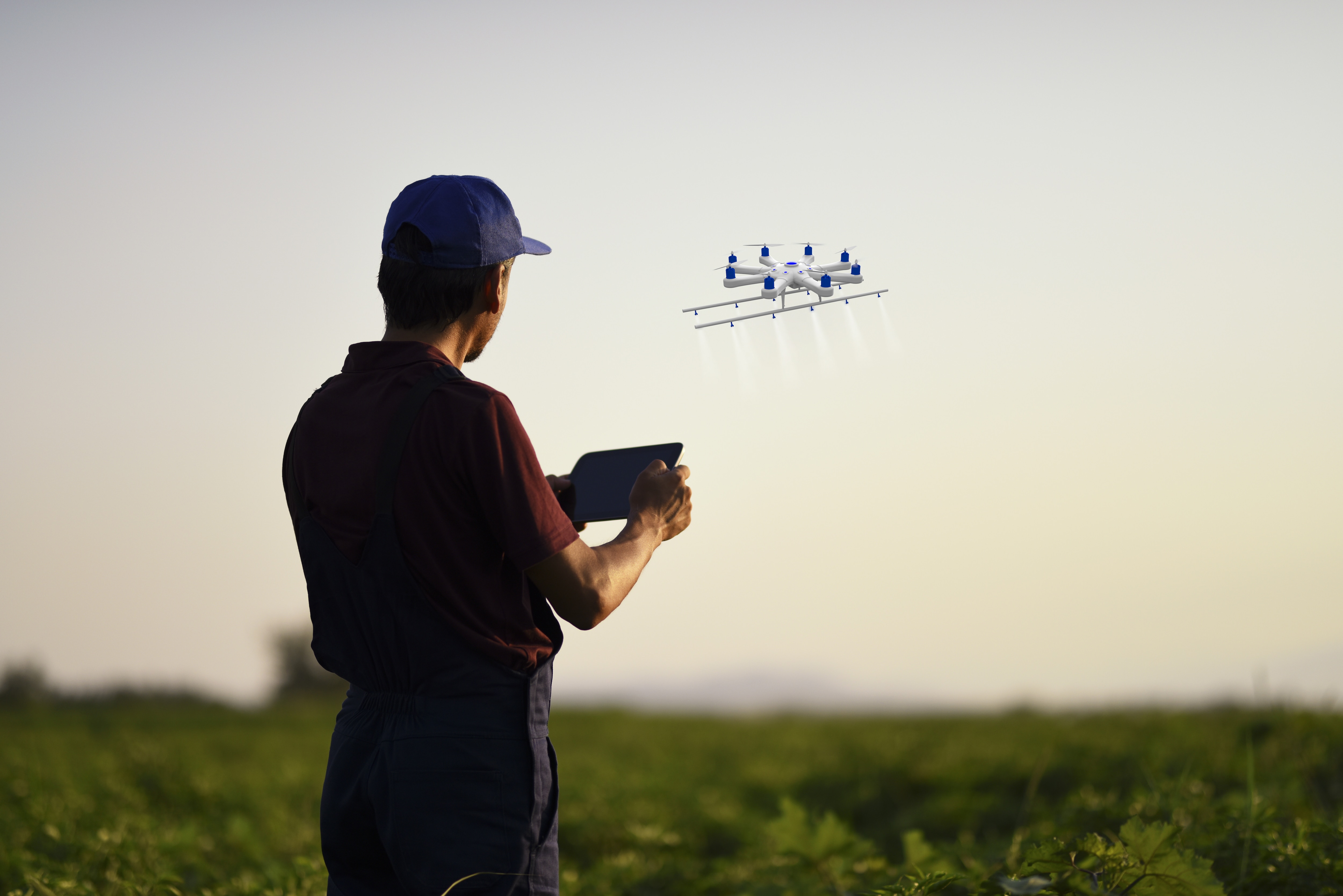 Farmer spraying his crops using a drone; food systems innovation