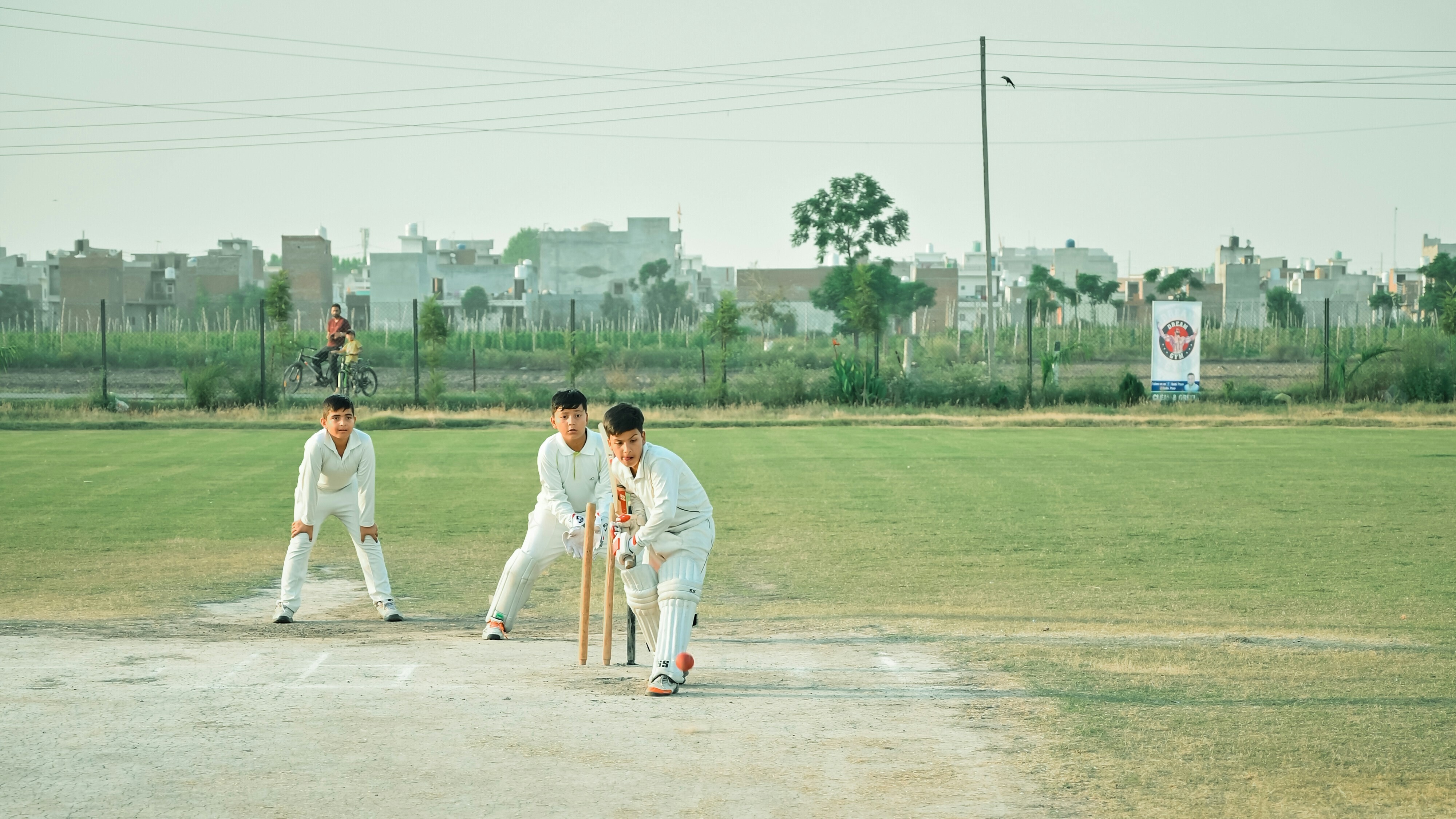 Children play in a cricket match, reflecting grassroots participation in the sports economy.