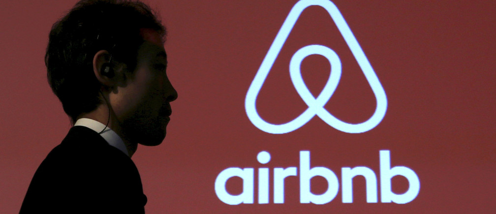 A man walks past a logo of Airbnb after a news conference in Tokyo, Japan, November 26, 2015. REUTERS/Yuya Shino/File Photo - RTSHFSD