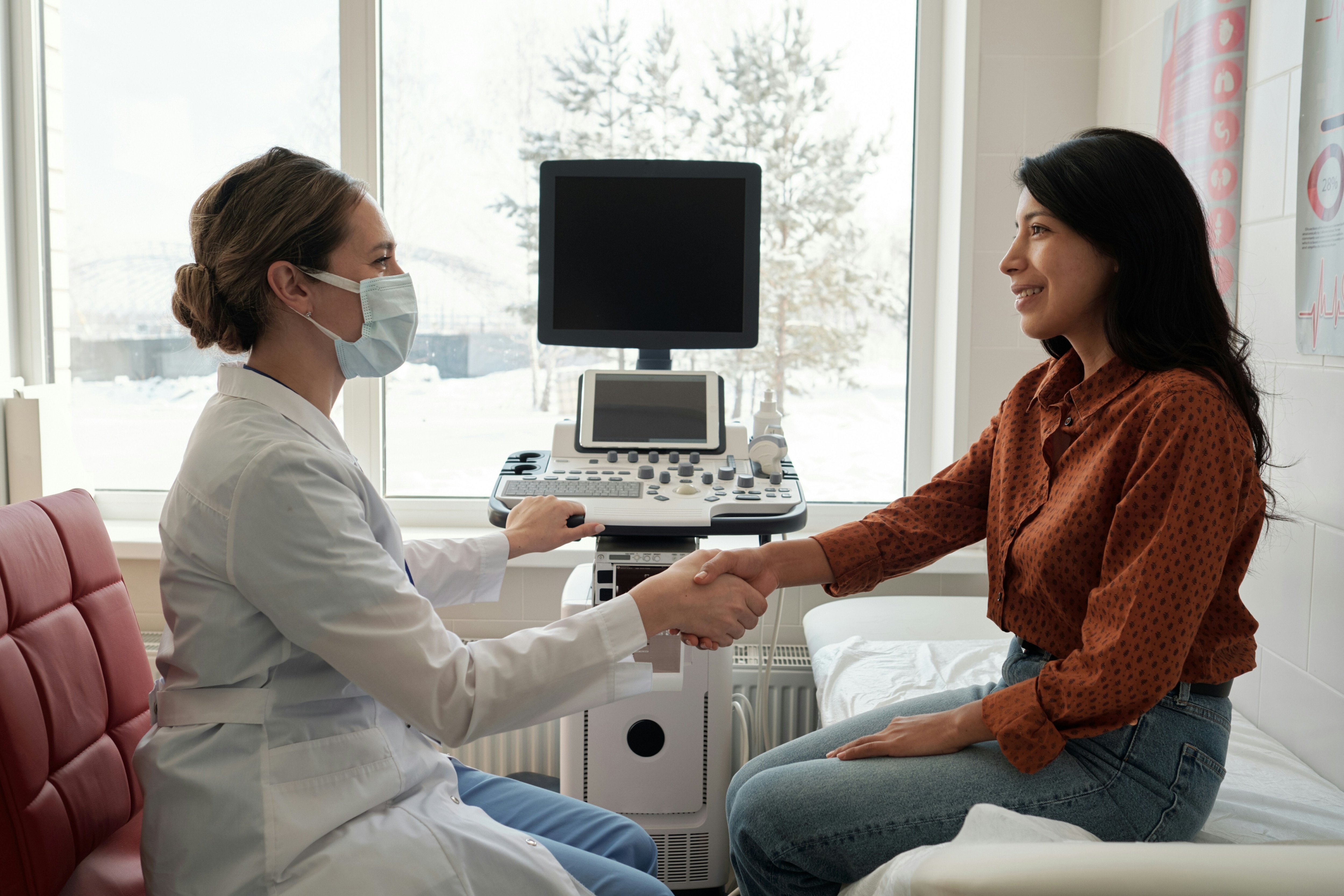 A side view of a woman being treated by a female doctor: Bedside diagnosis has been the norm before AI 