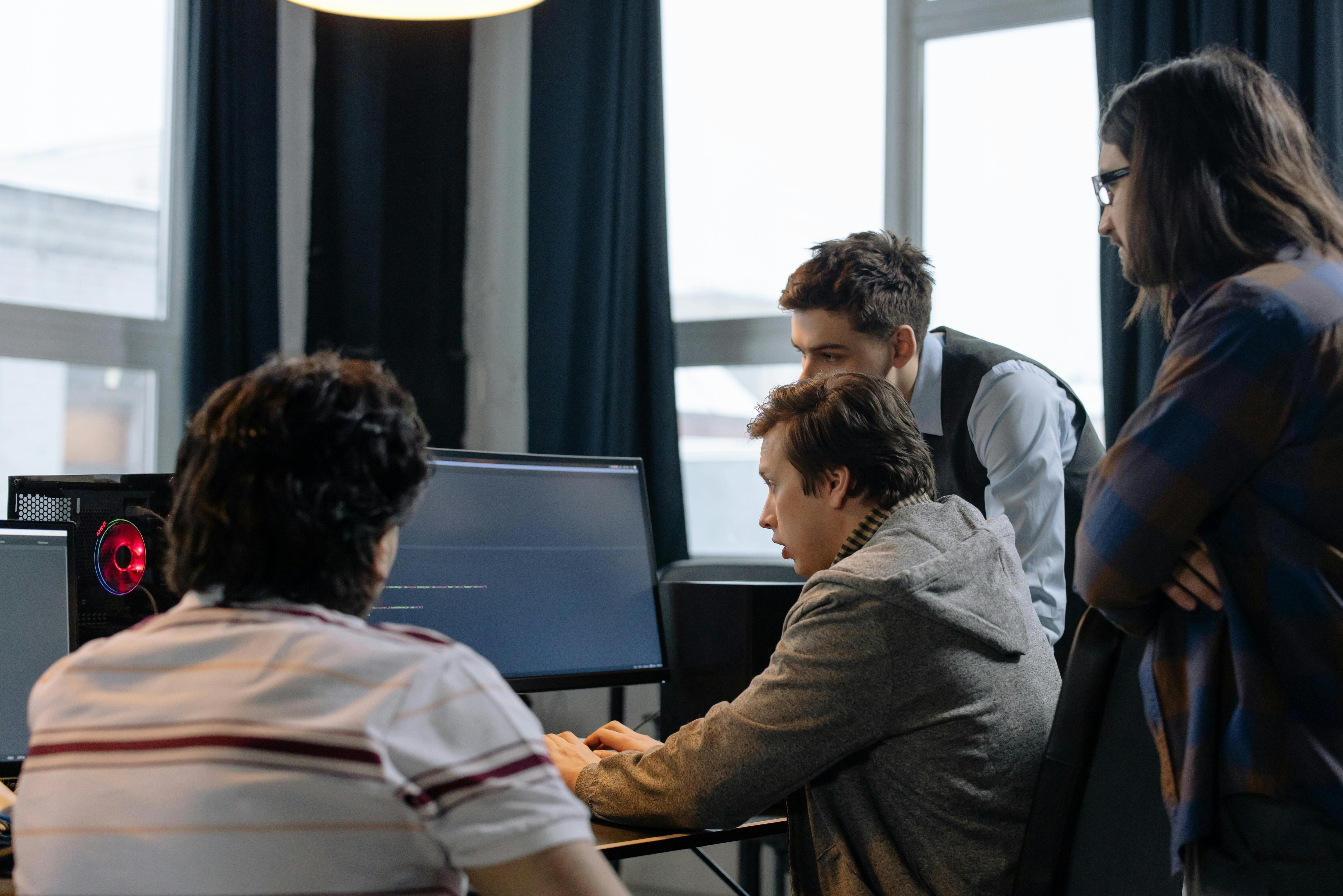A group of people crowd around a computer: Combatting cybercrime requires multiple players